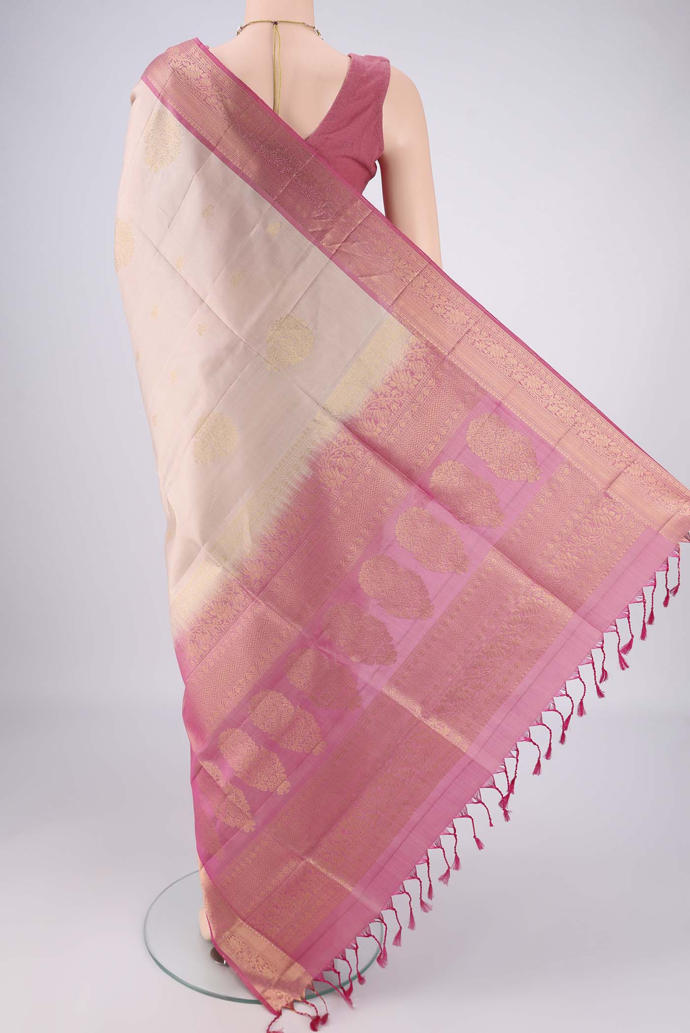 Flat view of Beige Soft Silk Saree with Zari Butta on the body and Zari Border. 