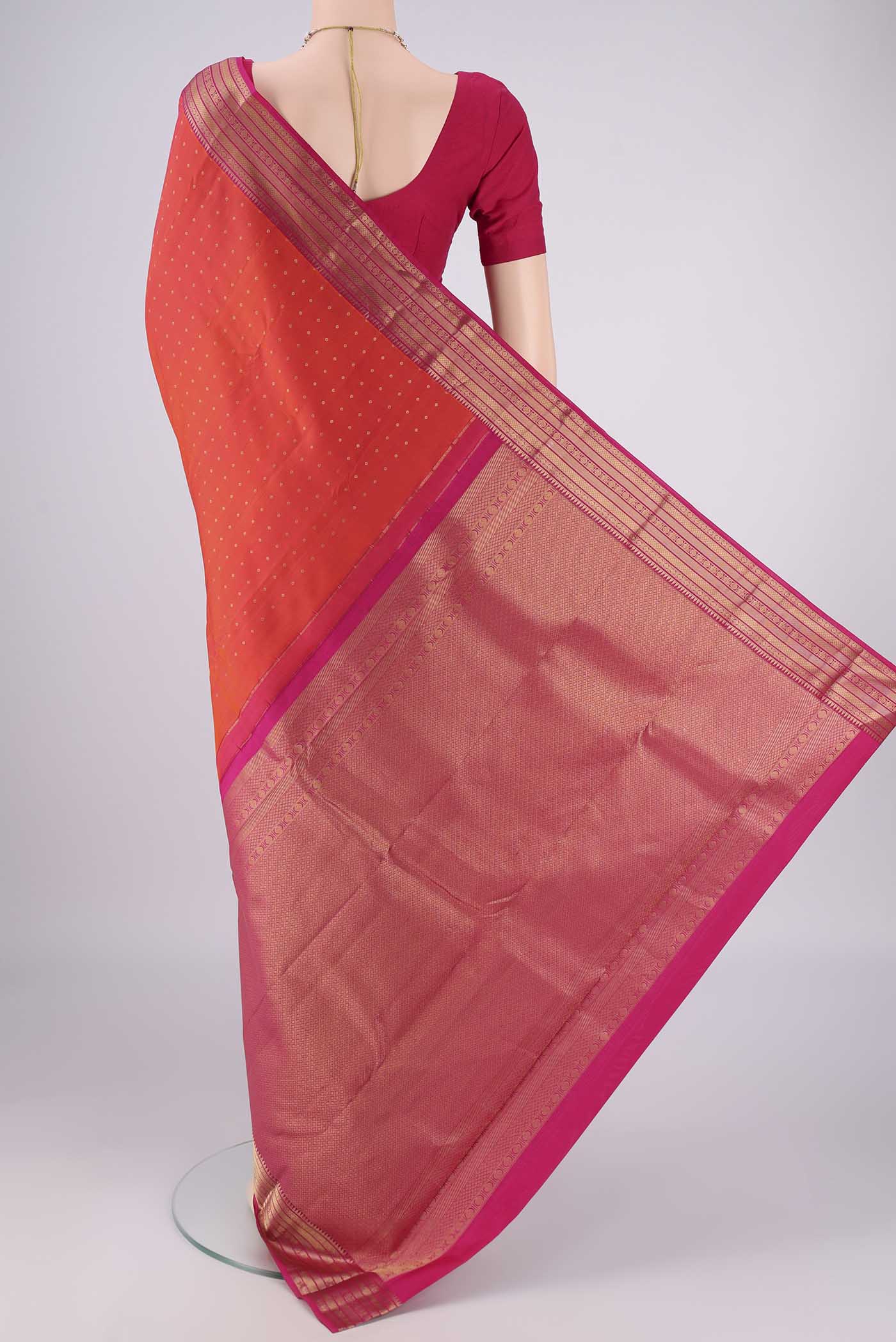Flat view of Orange Kanchipuram Silk Saree with Zari Butta on the body and Zari Border. 