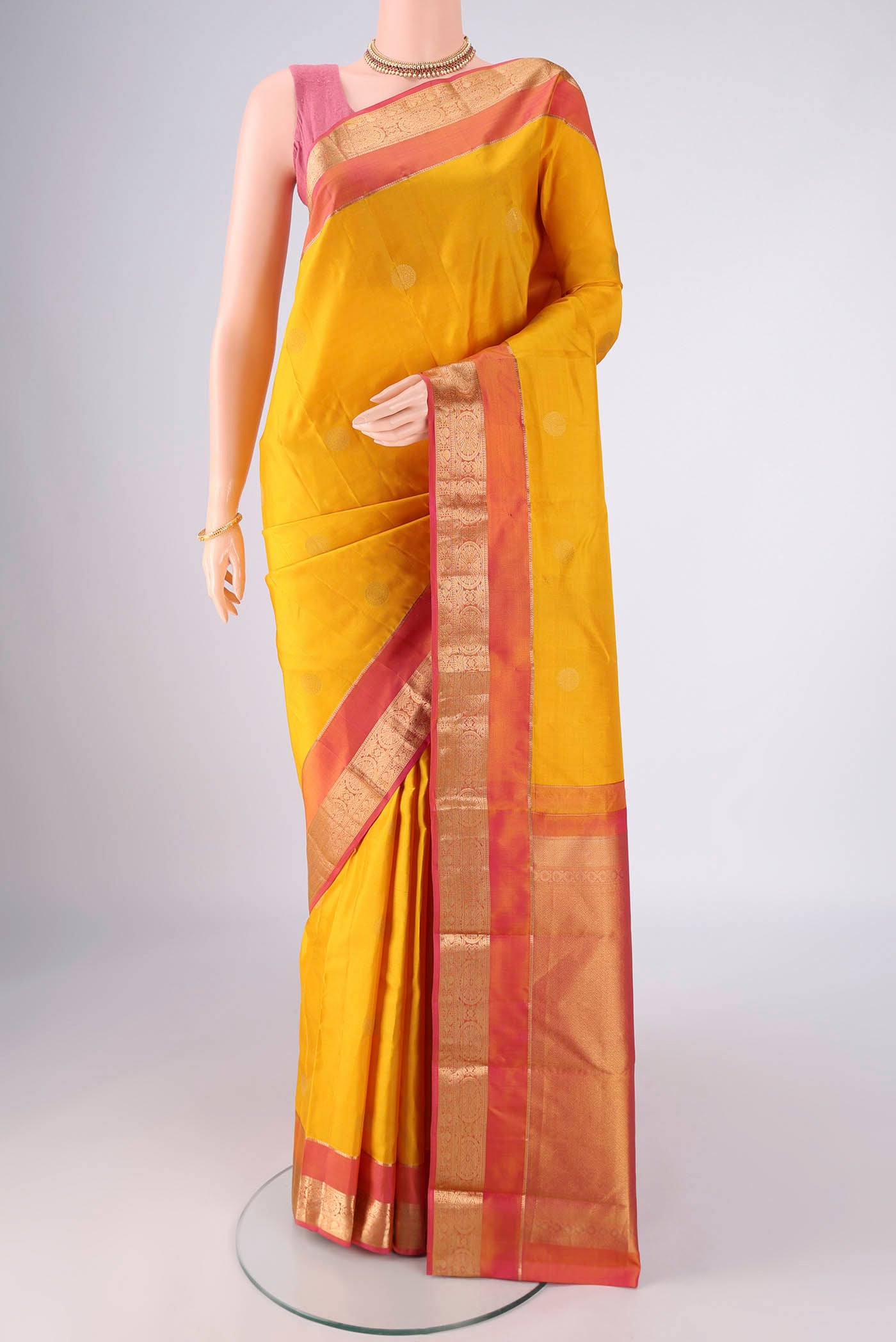 Yellow Kanchipuram Silk Saree with Zari Butta on the body and Zari Border.  displayed on a mannequin