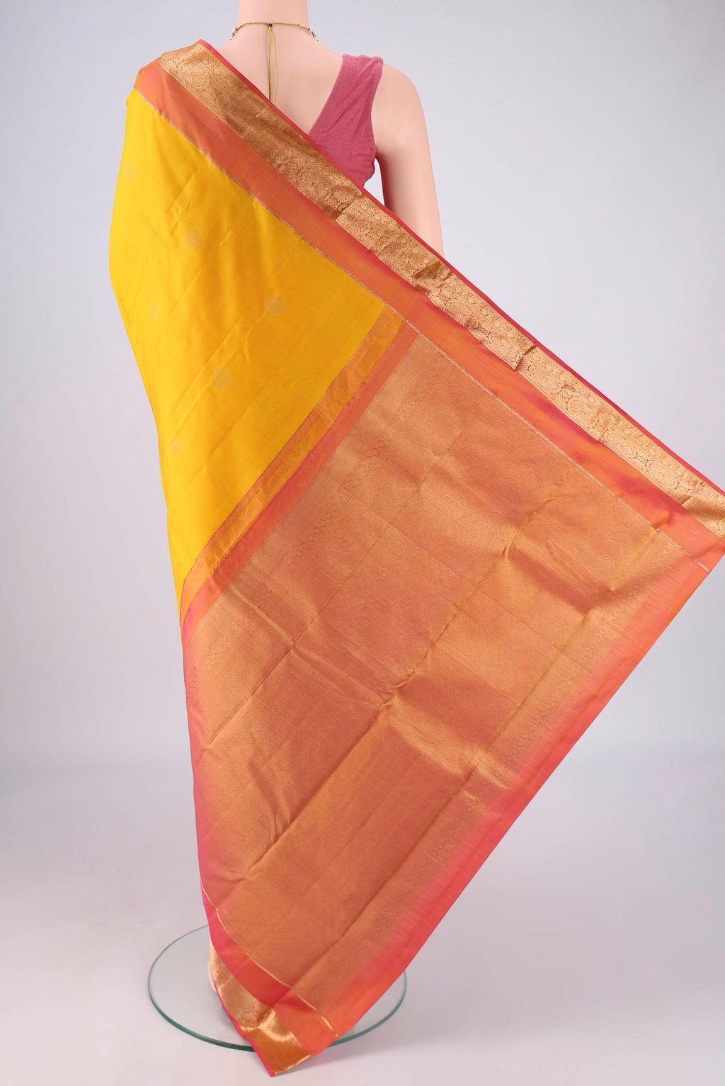 Flat view of Yellow Kanchipuram Silk Saree with Zari Butta on the body and Zari Border. 
