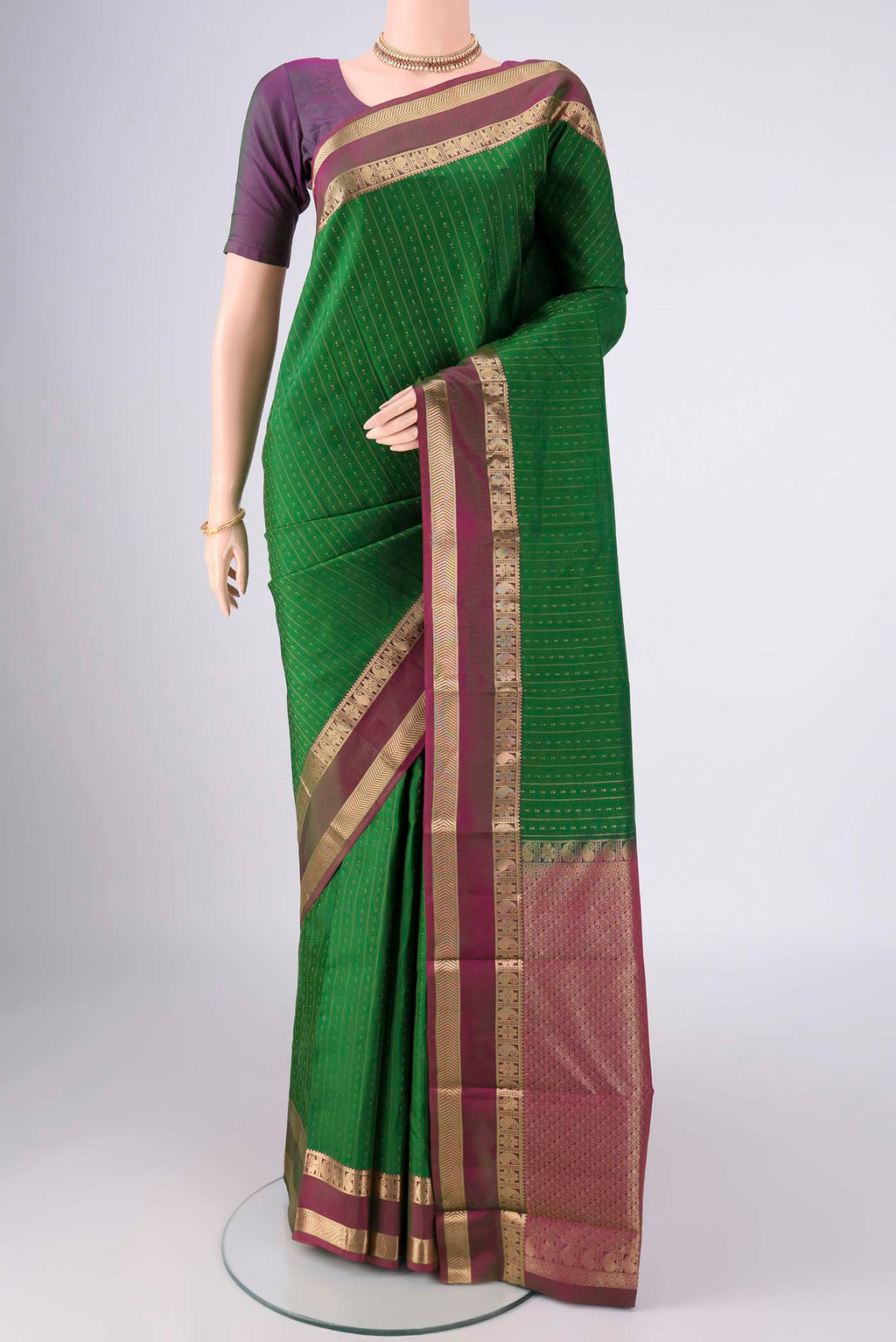 Green Kanchipuram Silk Saree with Zari Butta on the body and Zari Border.  displayed on a mannequin