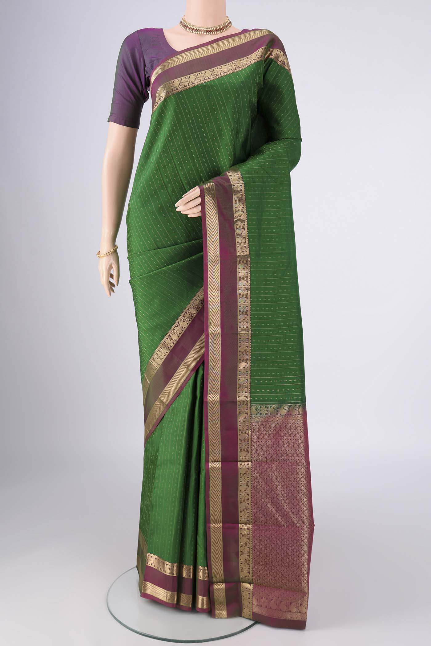 Green Kanchipuram Silk Saree with Zari Butta on the body and Zari Border.  displayed on a mannequin