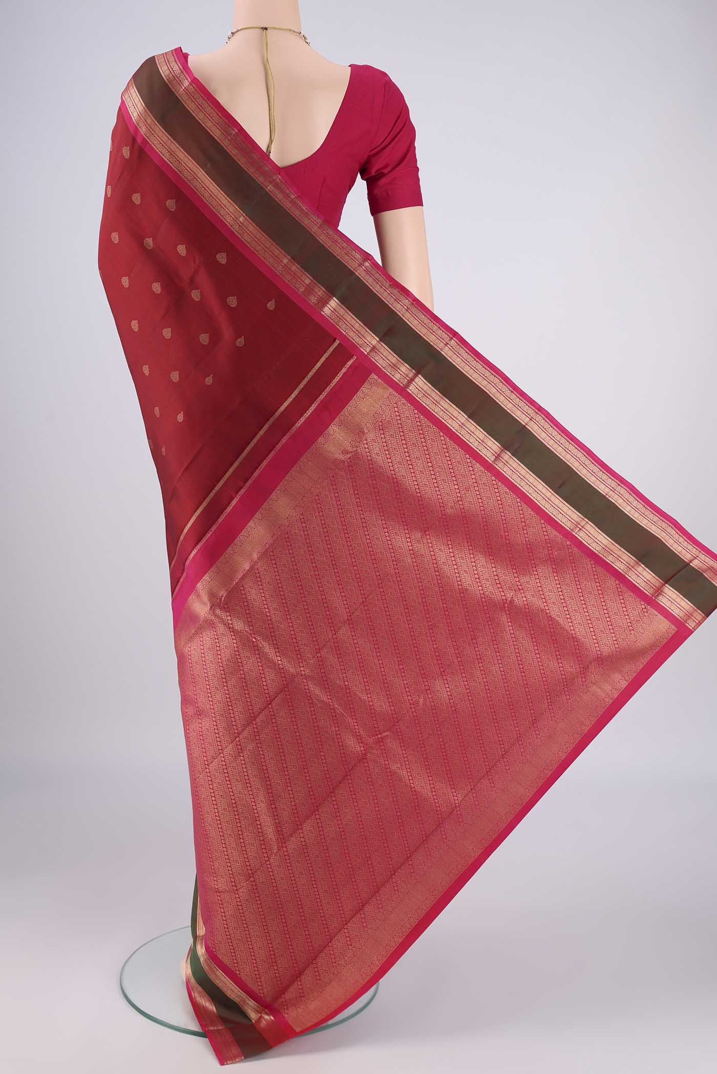 Flat view of Maroon Kanchipuram Silk Saree with Zari Butta on the body and Zari Border. 