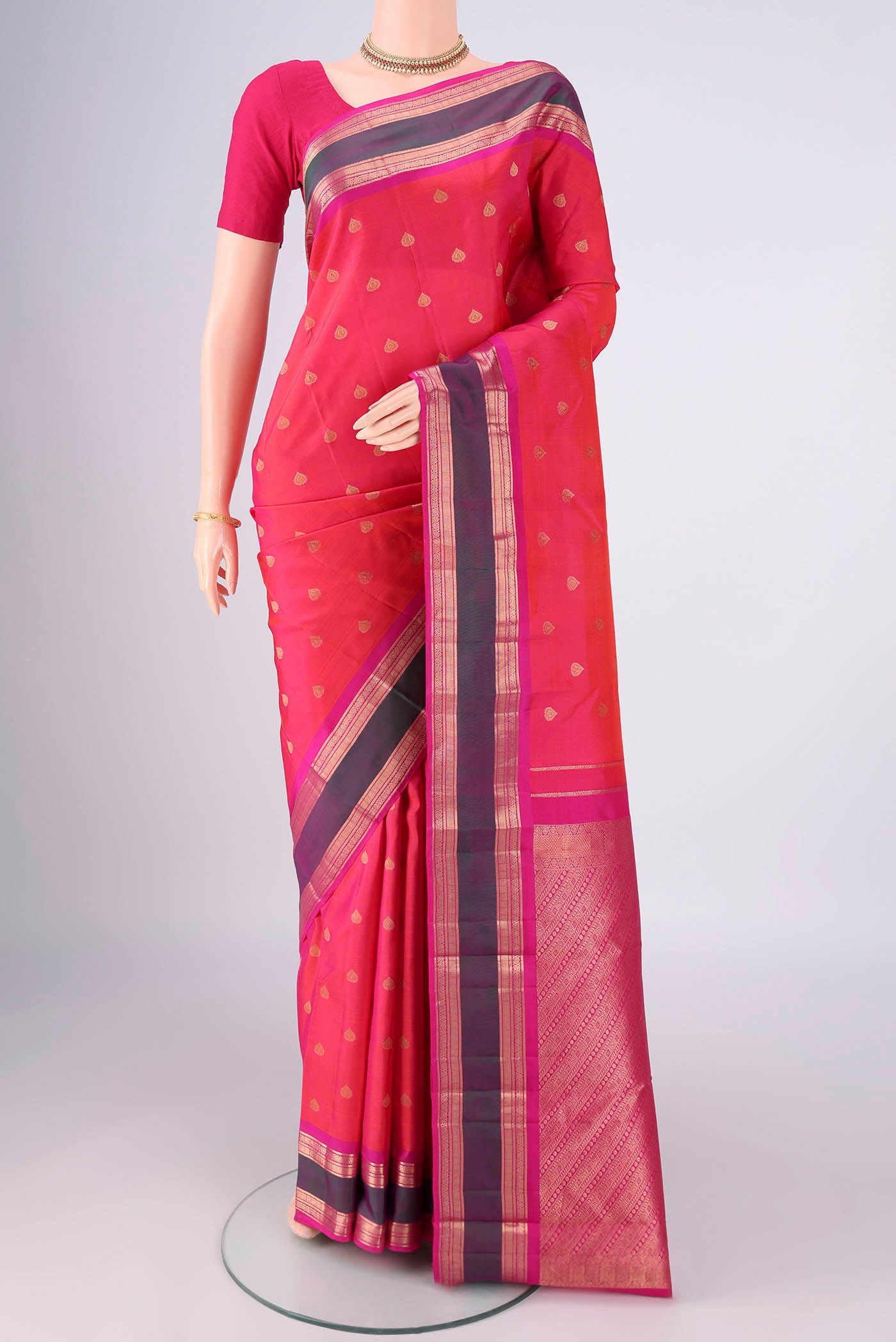 Coral Dual Tone Kanchipuram Silk Saree with Zari Butta on the body and Zari Border.  displayed on a mannequin