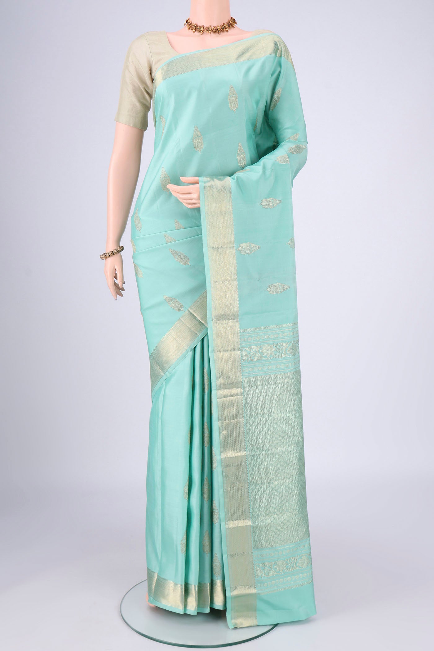 Mint Green Dual Tone Kanjivaram Saree with Zari Butta on the body and Zari Border.  displayed on a mannequin