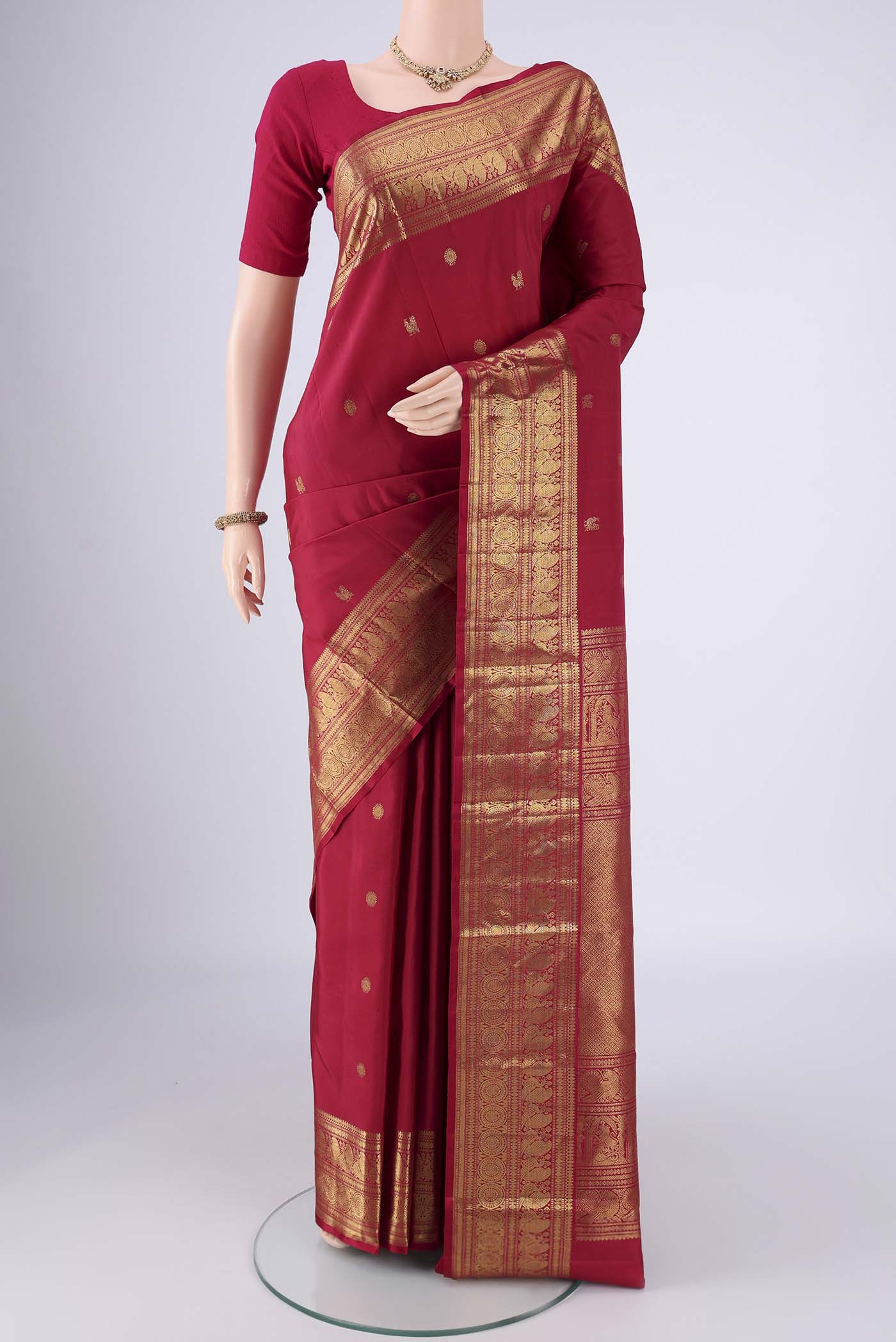Maroon Dual Tone Kanjivaram Saree with Zari Butta on the body and Zari Border.  displayed on a mannequin