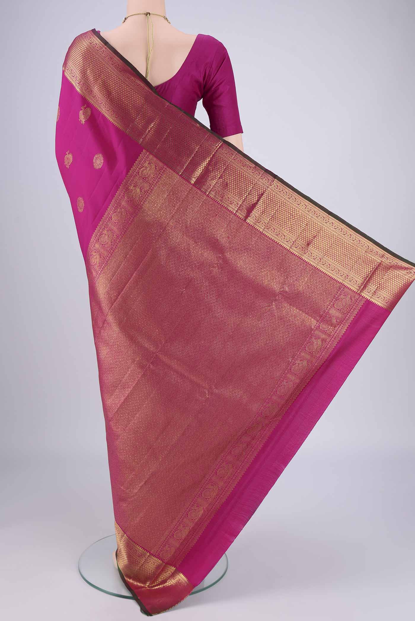 Flat view of Rani Pink Dual Tone Kanjivaram Saree with Zari Butta on the body and Zari Border. 