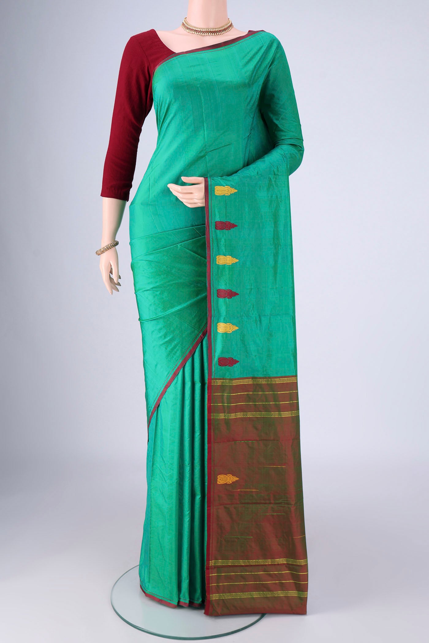 Sea Green Kanchipuram Silk Saree with Plain Body and Thread Border.  displayed on a mannequin