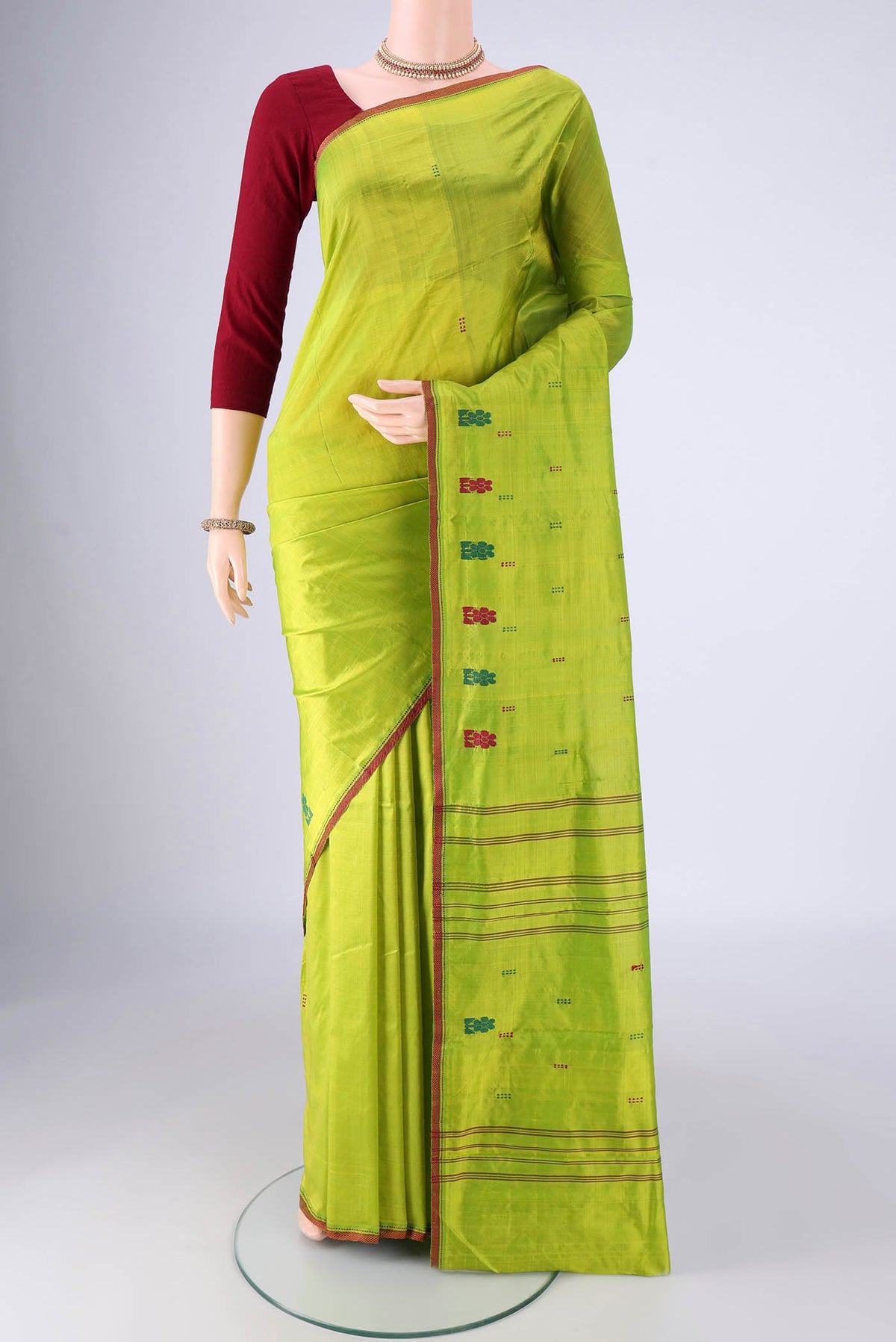 Parrot Green Kanchipuram Silk Saree with Thread Butta on the body and Thread Border.  displayed on a mannequin