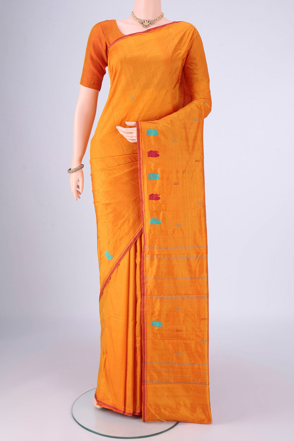 Orange Kanchipuram Silk Saree with Plain Body and Thread Border.  displayed on a mannequin