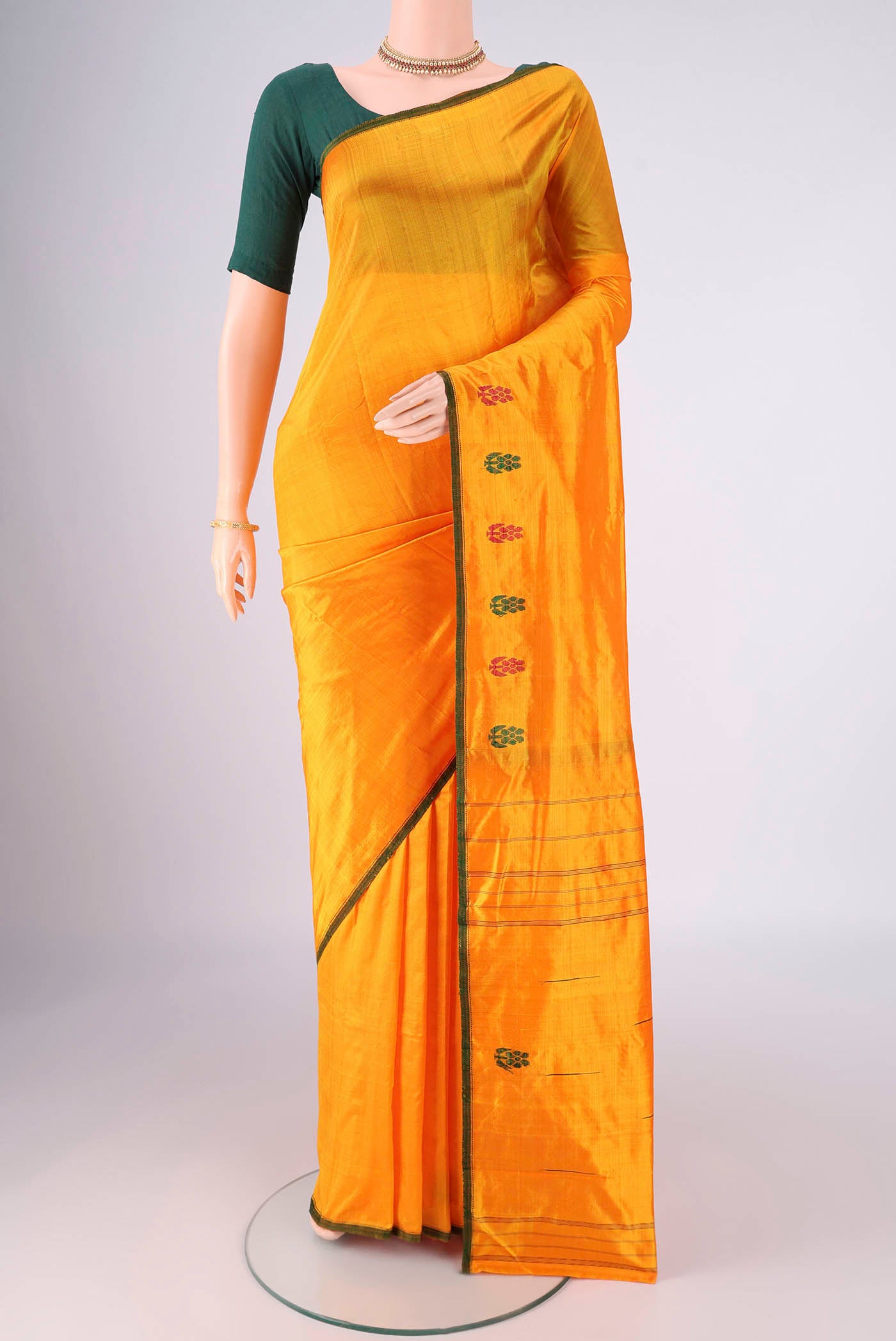 Orange Kanchipuram Silk Saree with Plain Body and Thread Border.  displayed on a mannequin
