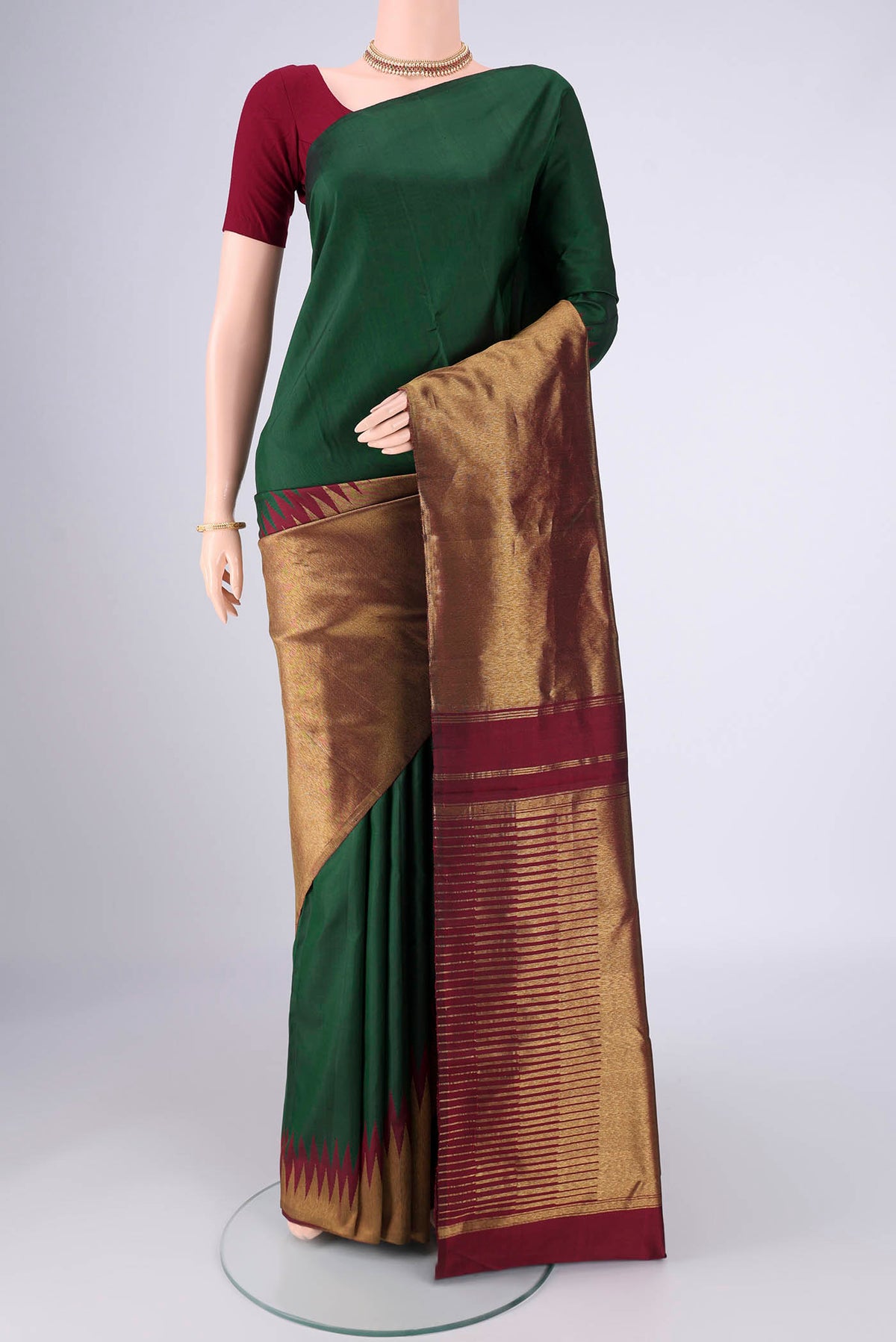 Bottle Green Kanjivaram Silk Saree with Plain Body and Rising Temple Border.  displayed on a mannequin