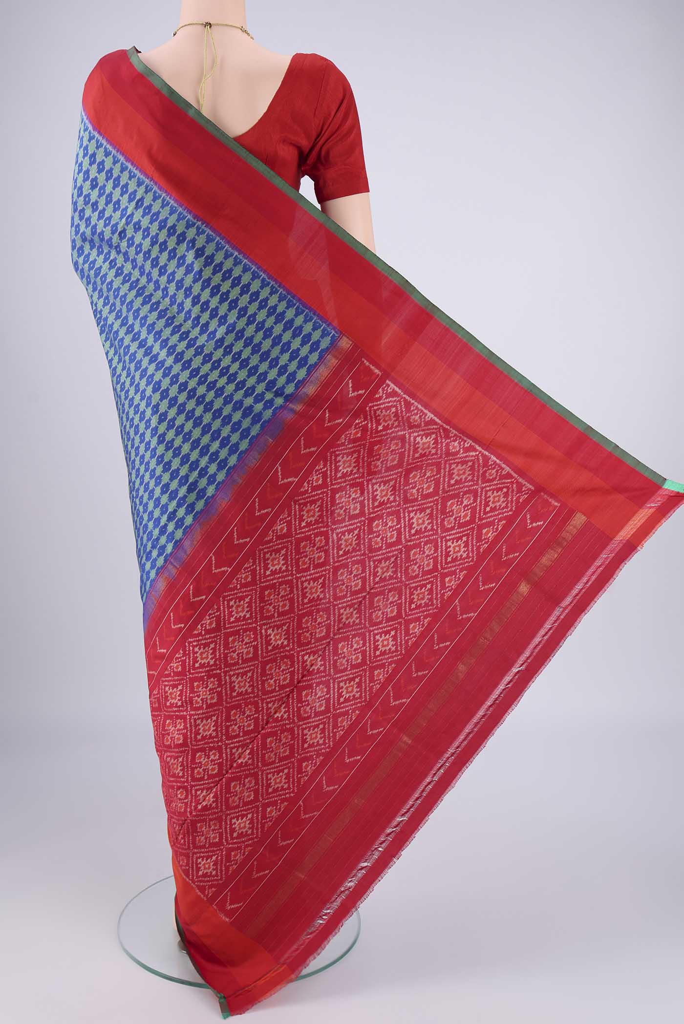 Flat view of Blue Pochampally Silk Saree with Ikat design on the body and Zari Border. 