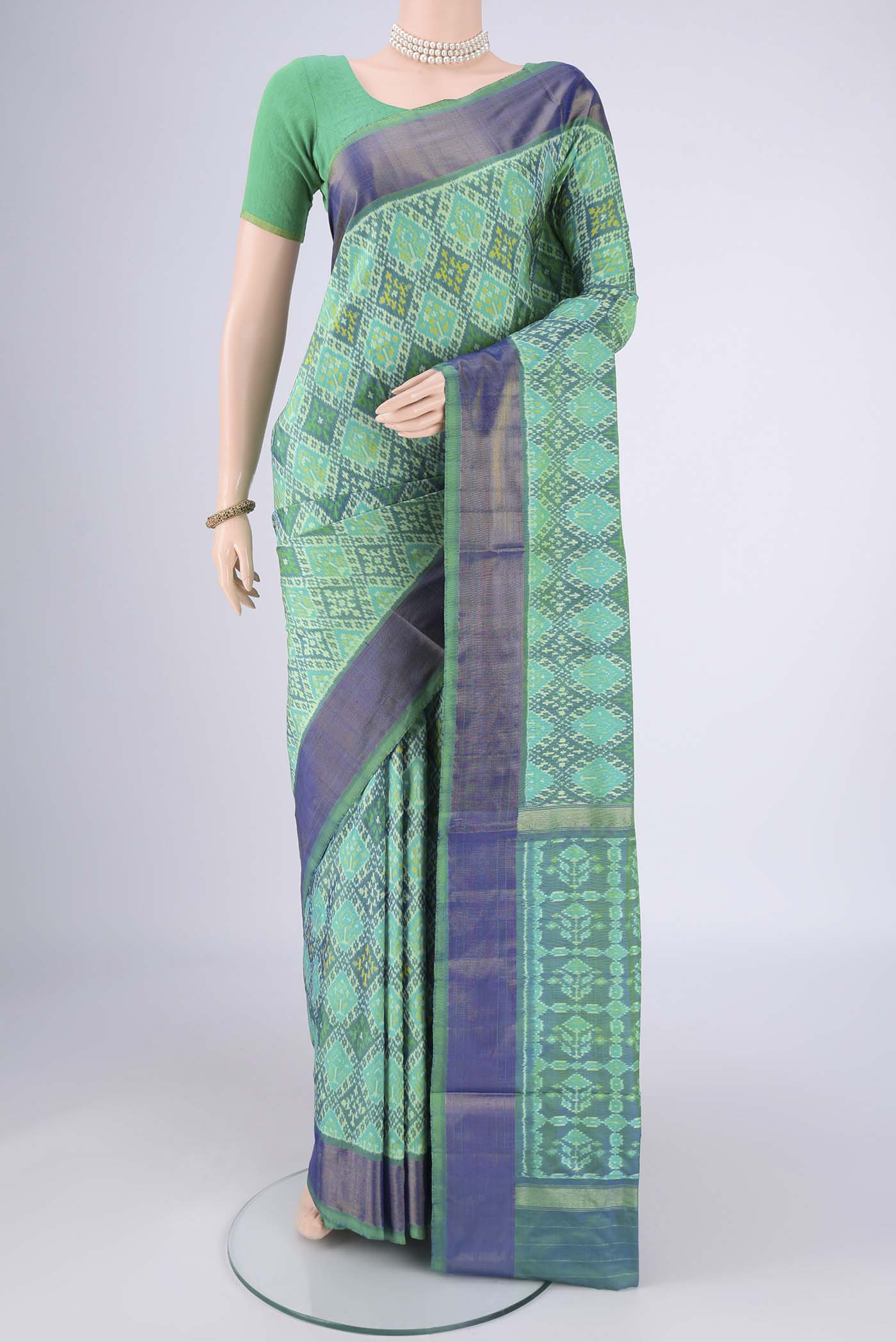 Sea Green Pochampally Silk Saree with Ikat design on the body and Zari Border.  displayed on a mannequin