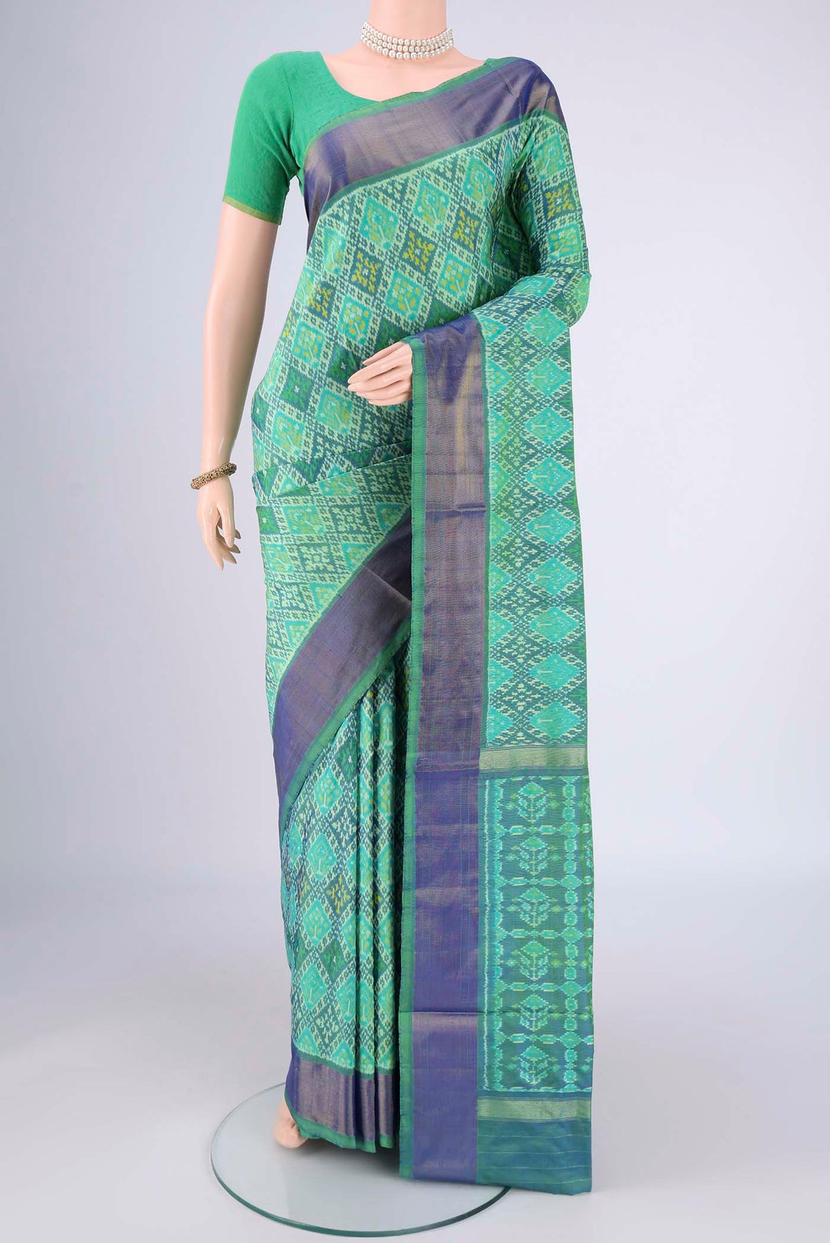 Sea Green Pochampally Silk Saree with Ikat design on the body and Zari Border.  displayed on a mannequin