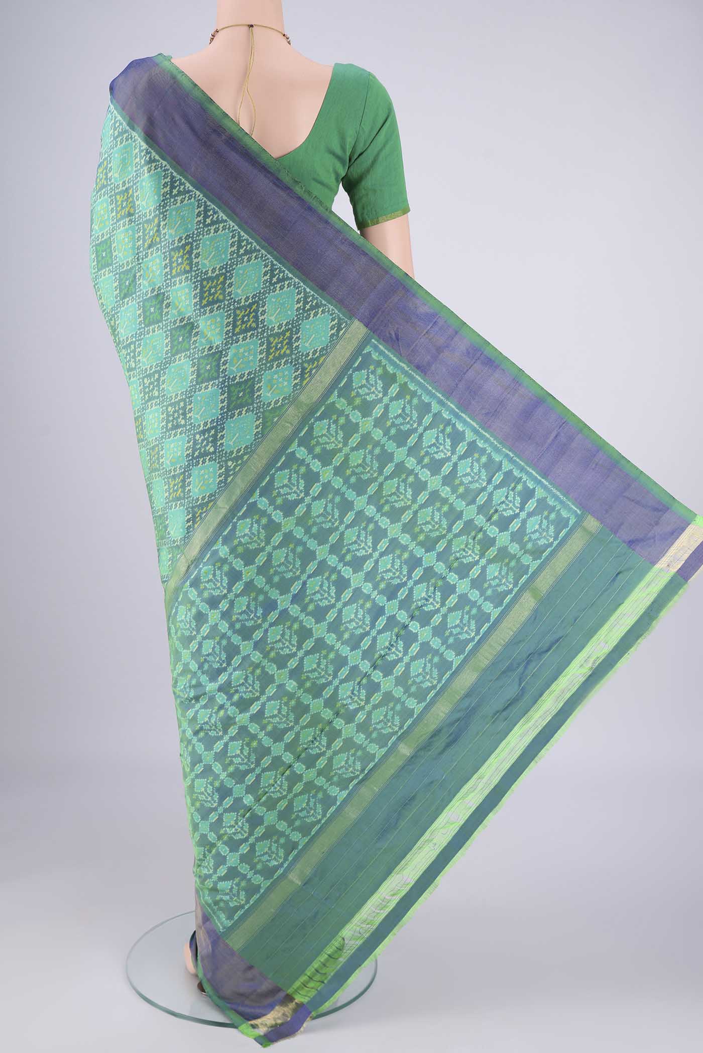 Flat view of Sea Green Pochampally Silk Saree with Ikat design on the body and Zari Border. 