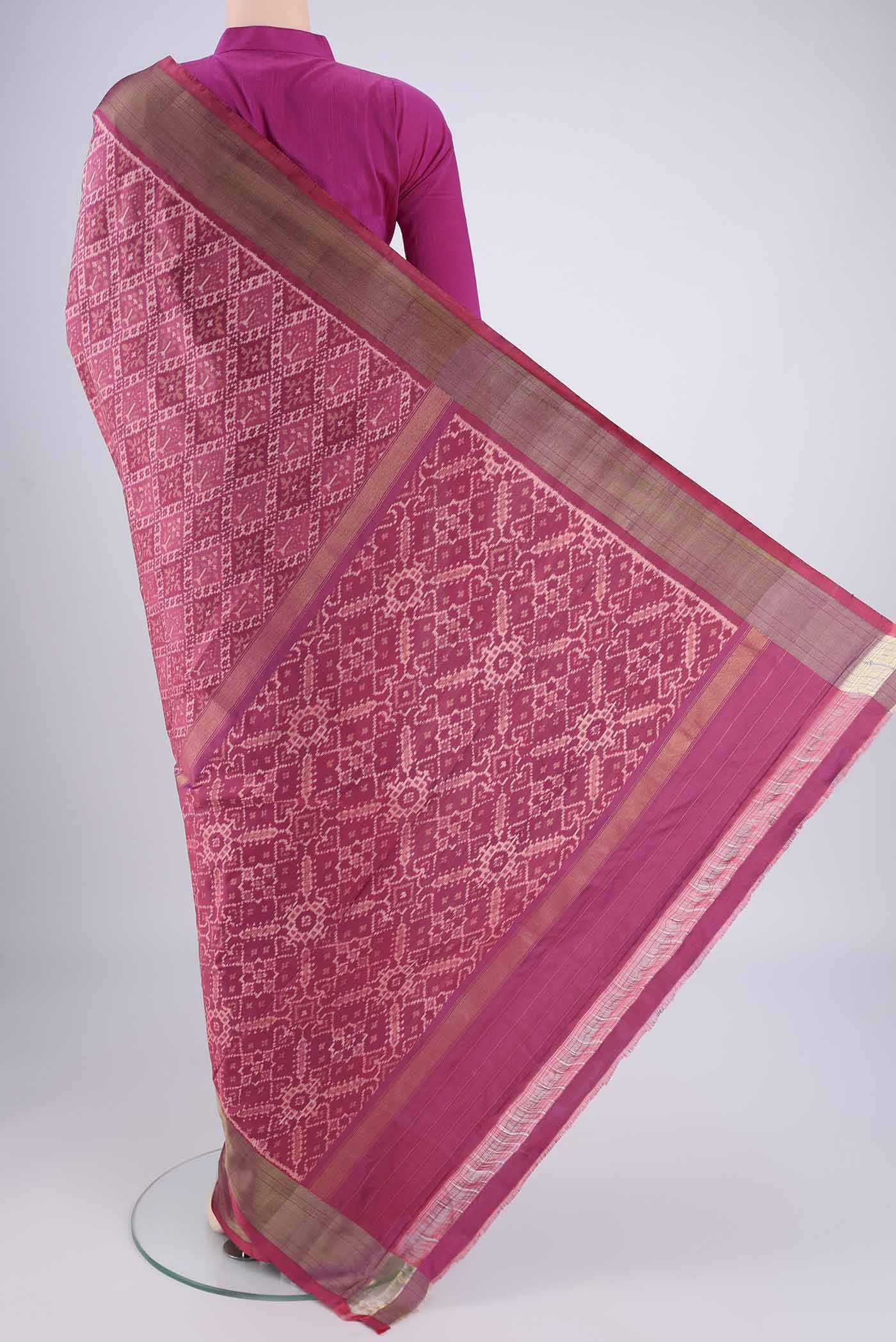 Flat view of Rose Gold Pochampally Silk Saree with Ikat design on the body and Zari Border. 