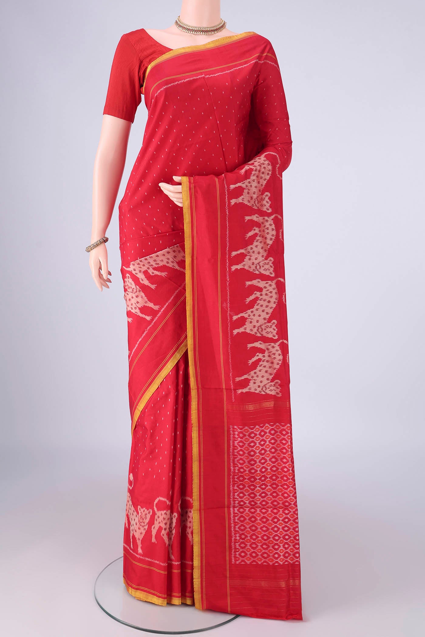 Red Kanjivaram Silk Saree with Pure Ikat on the body and Plain Border.  displayed on a mannequin
