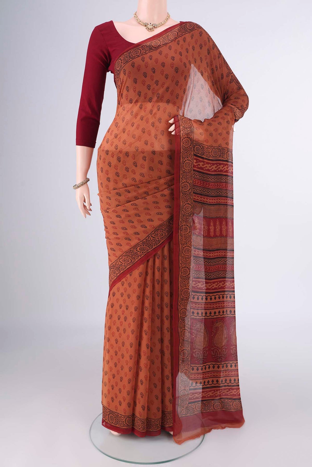 Rust Mysore Chiffon Saree with Floral Print on the body and Printed Border.  displayed on a mannequin