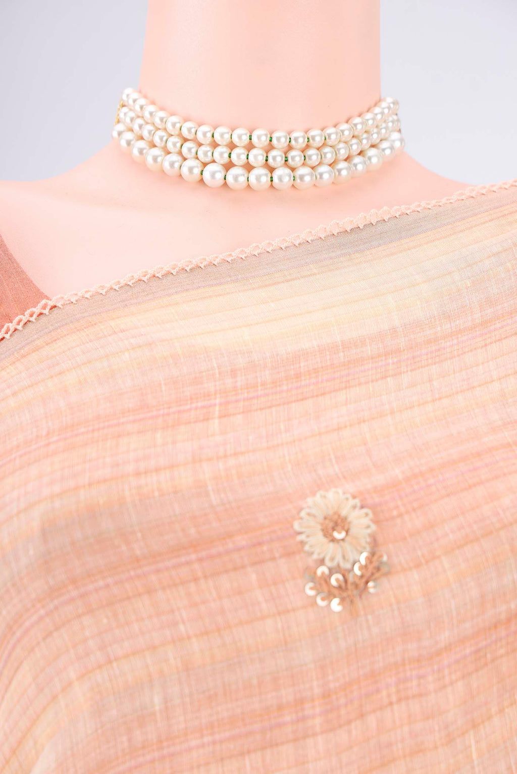 Border image of Golden Peach Linen Saree with Embroidery on the body and Lace Border. 