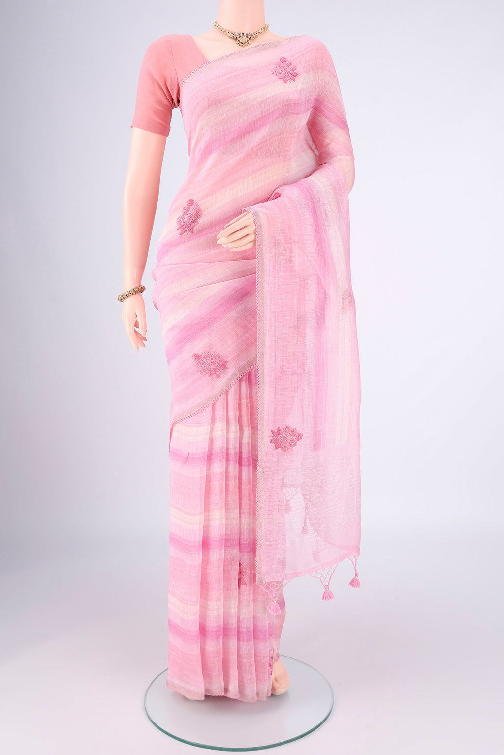 Pink Linen Saree with Embroidery on the body and Lace Border.  displayed on a mannequin