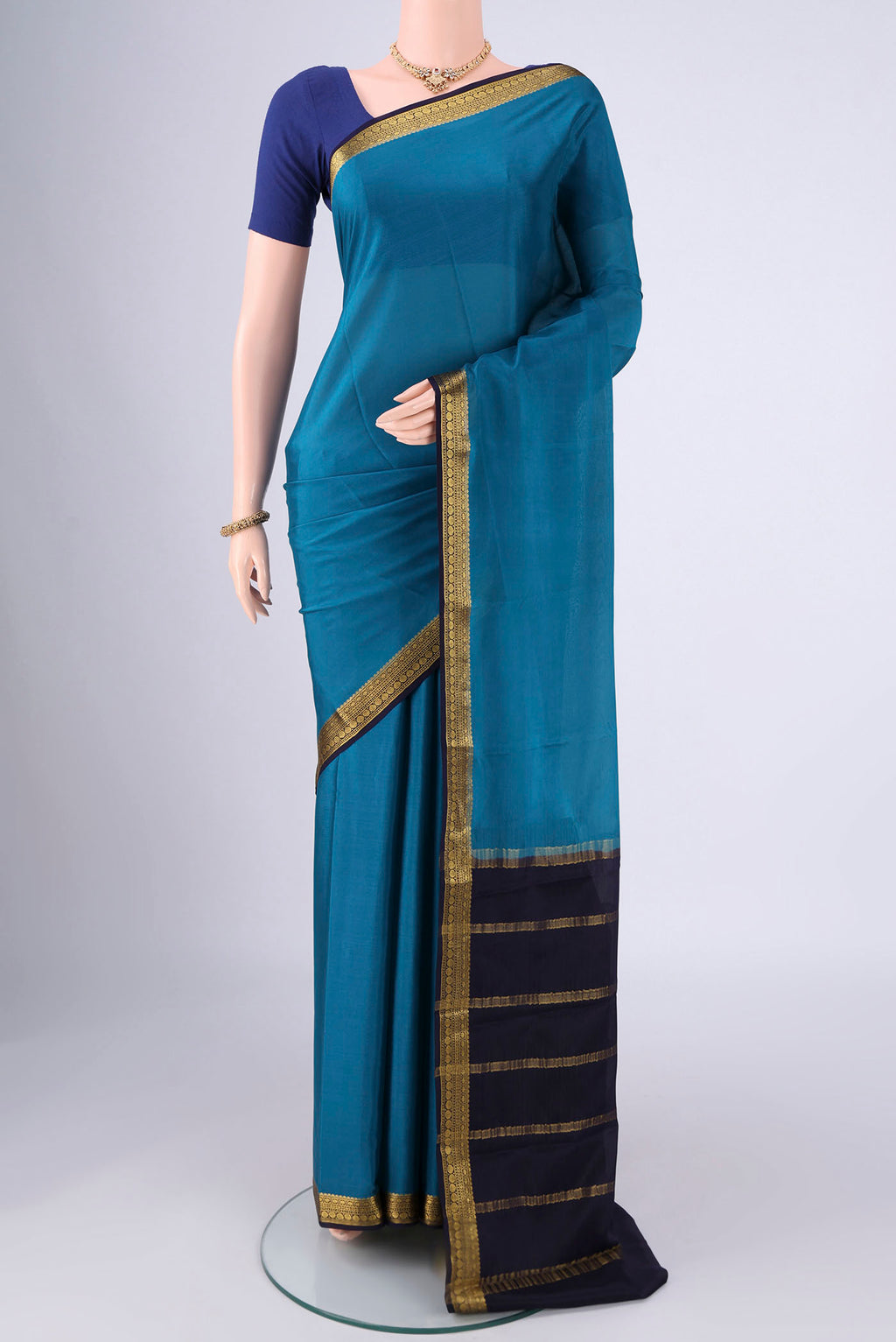 Teal Mysore Crepe Saree with Plain Body and Zari Border.  displayed on a mannequin