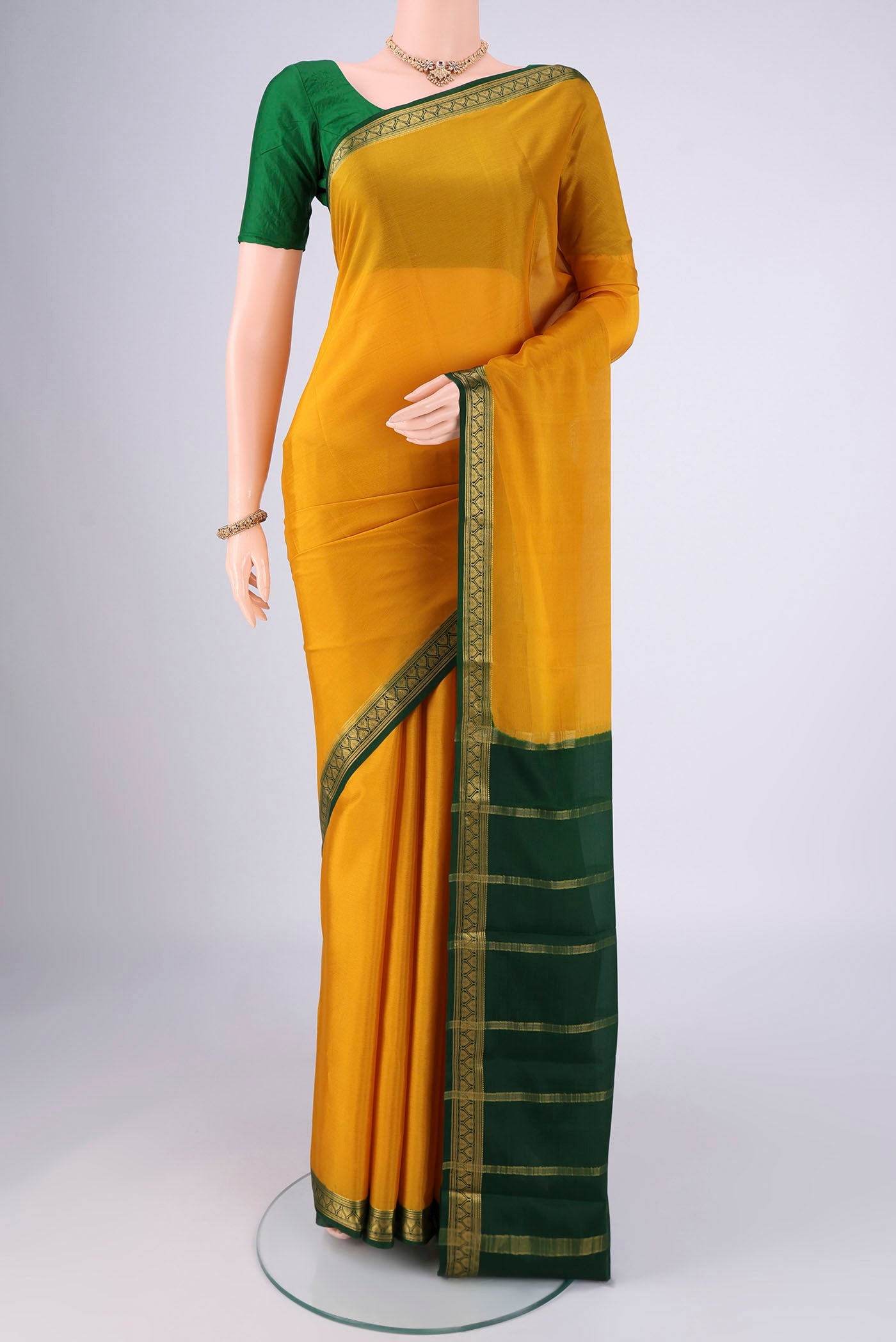 Mustard Mysore Crepe Saree with Plain Body and Zari Border.  displayed on a mannequin