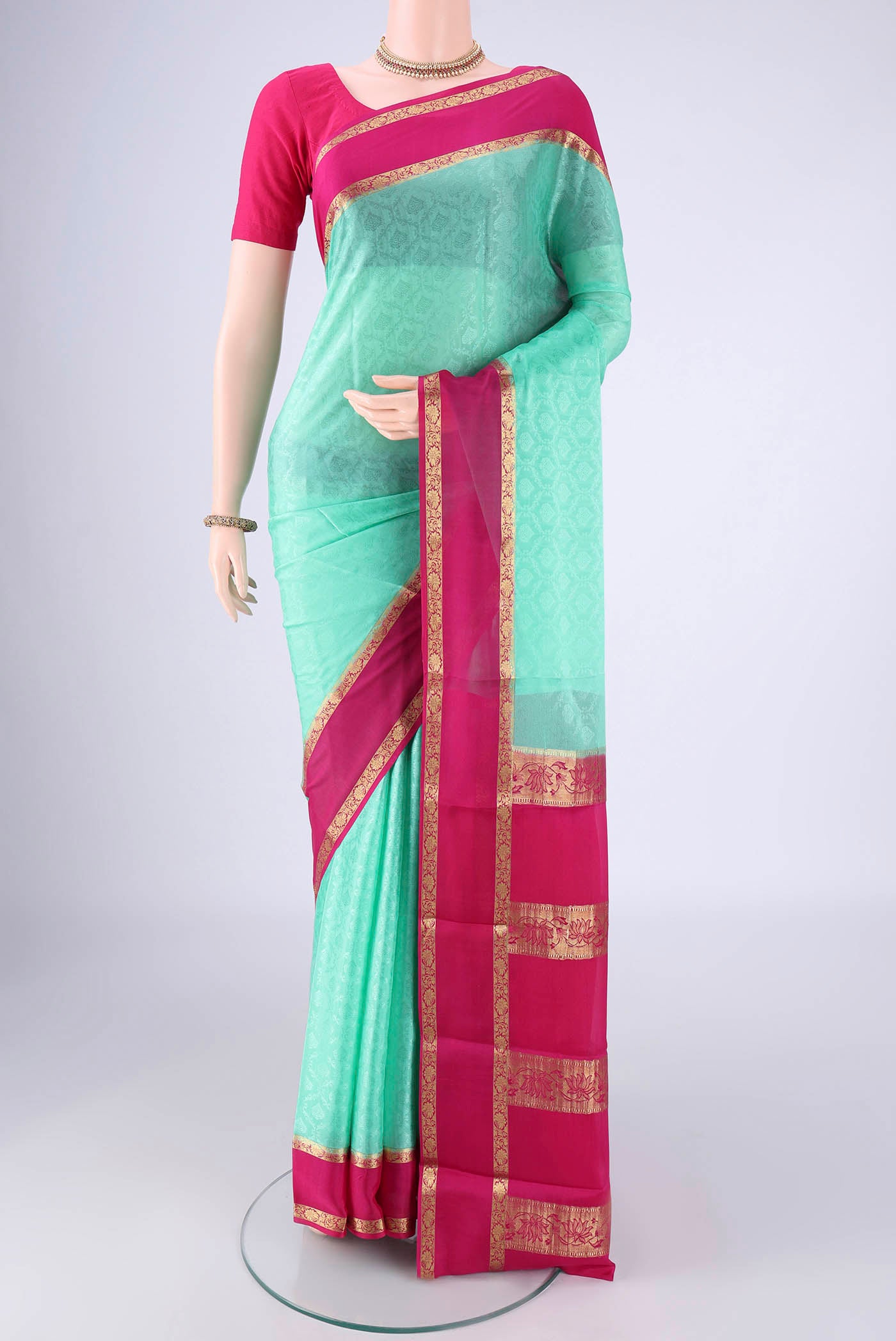 Turquoise Mysore Crepe Saree with Jacquard design on the body and Zari Border.  displayed on a mannequin