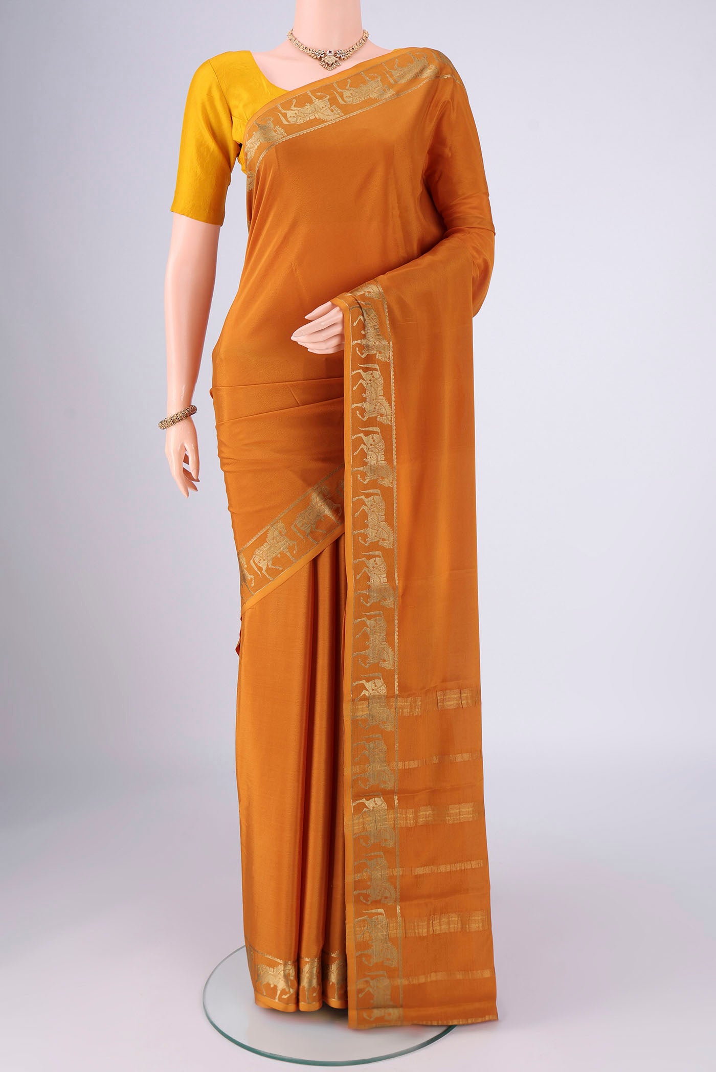 Mustard Mysore Crepe Saree with Plain Body and Zari Border.  displayed on a mannequin