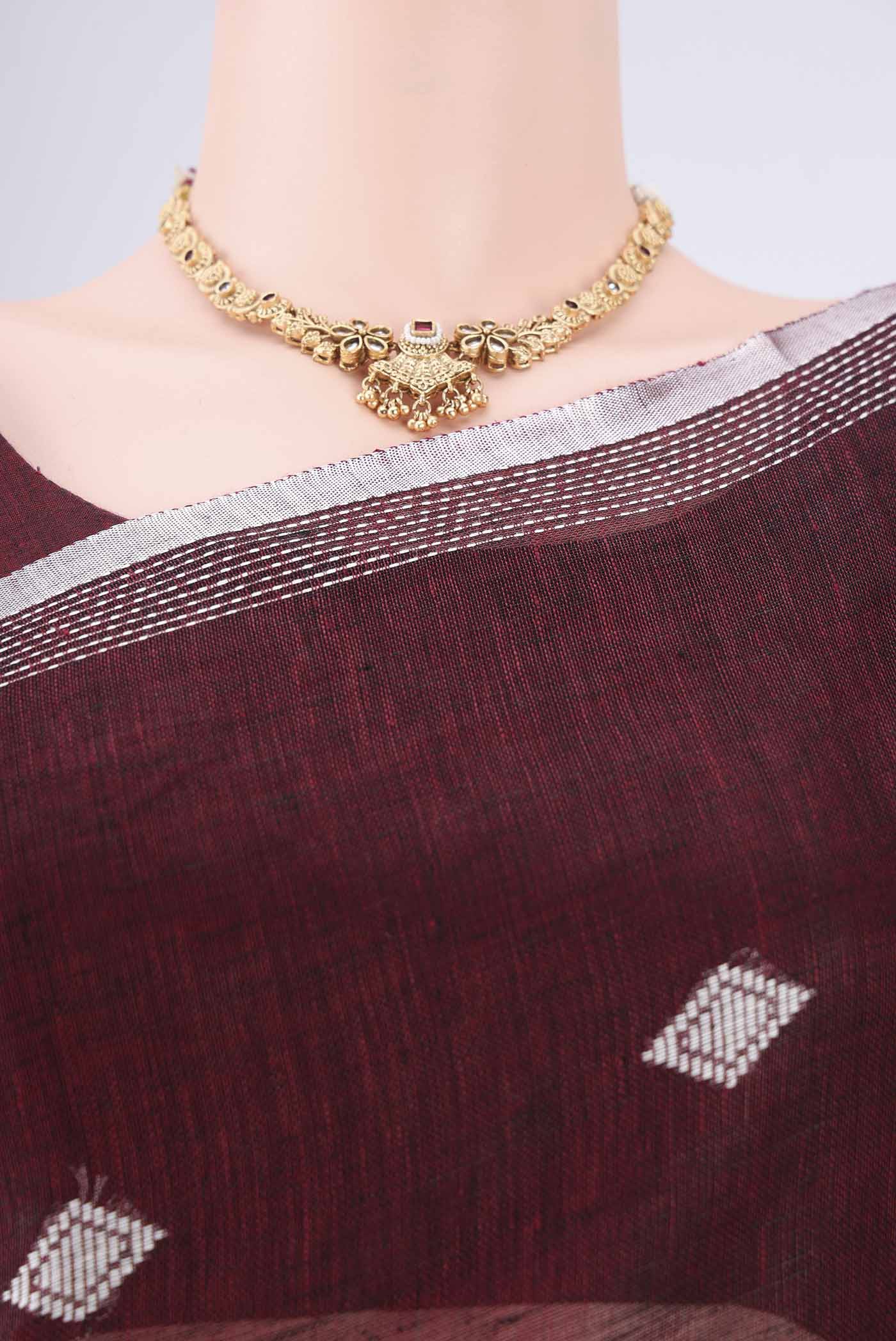 Border image of Maroon Linen Cotton Saree with Thread Butta on the body and Zari Border. 