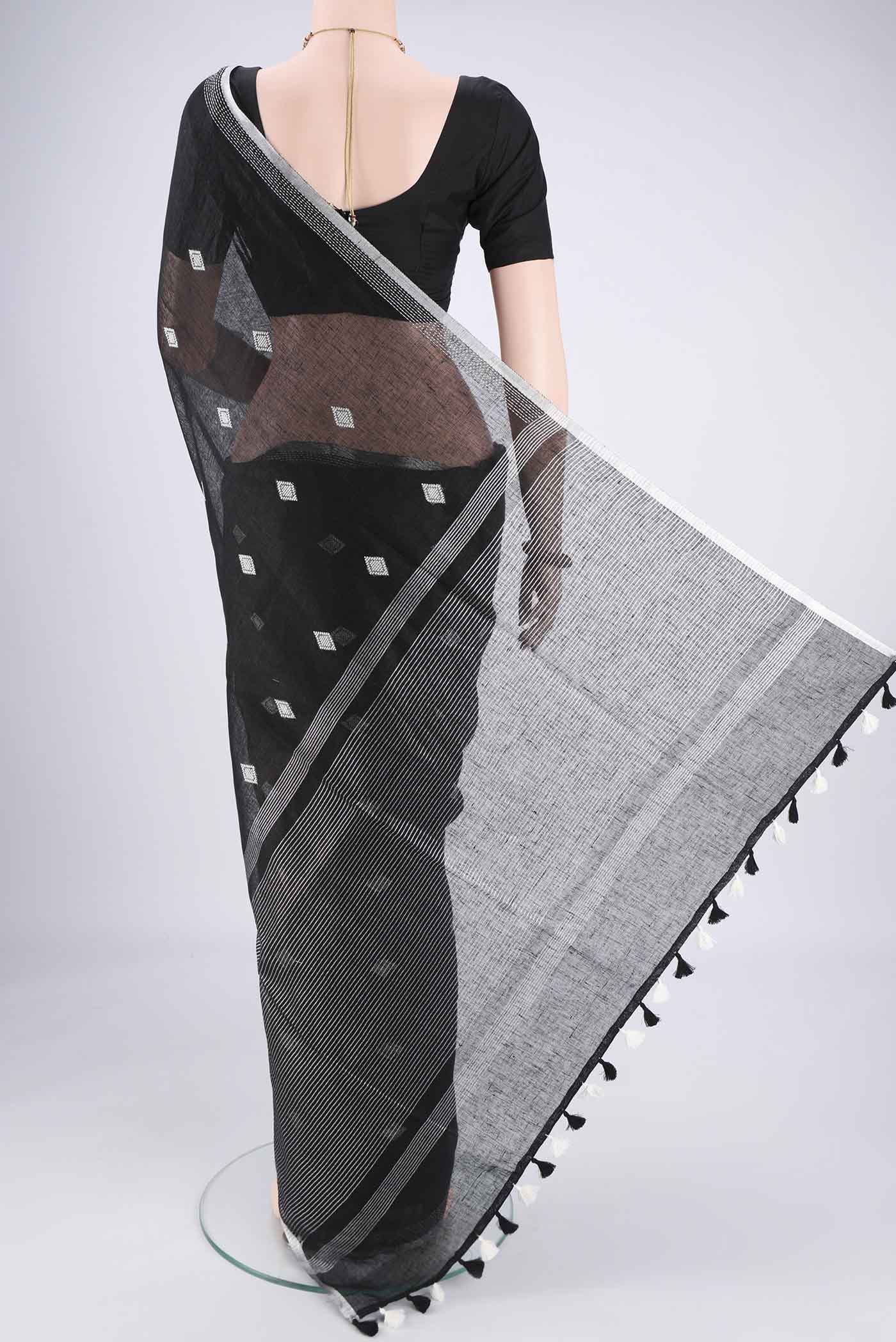 Flat view of Black Linen Cotton Saree with Thread Butta on the body and Zari Border. 