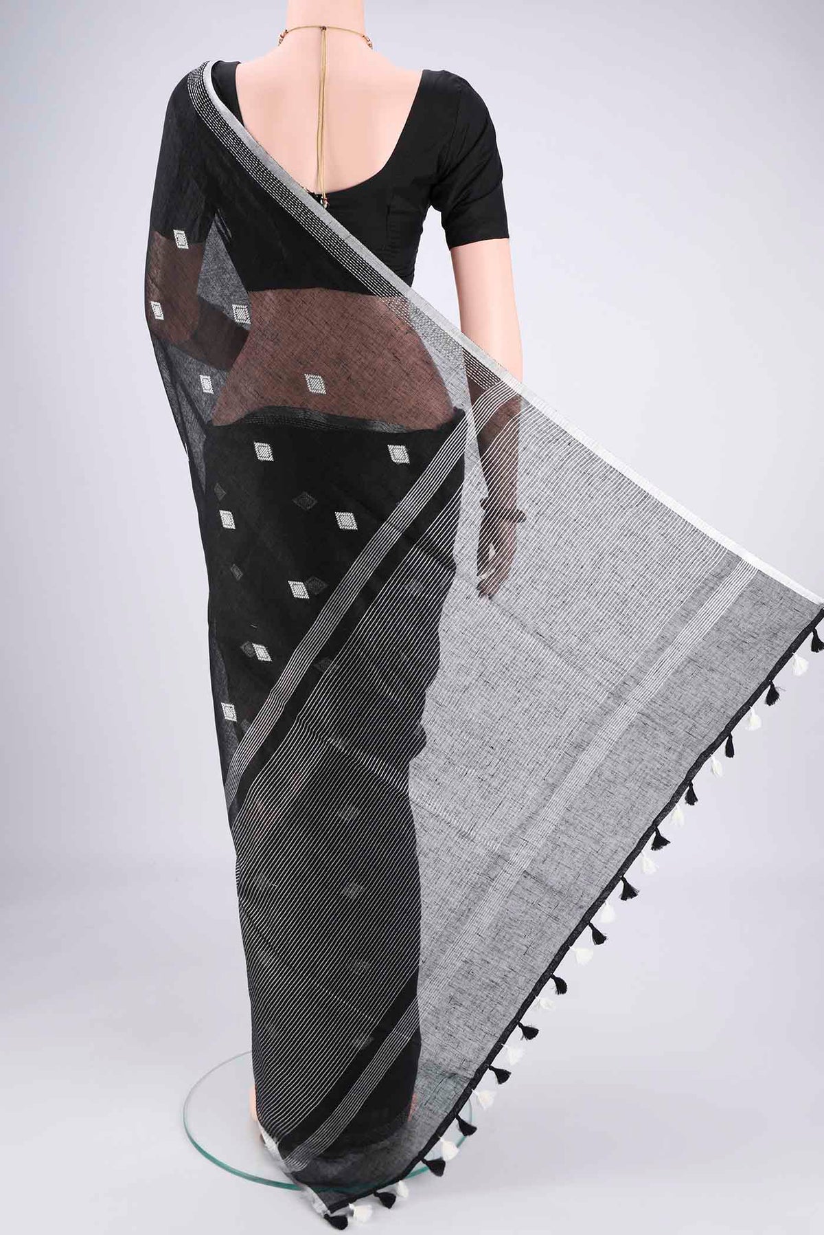 Flat view of Black Linen Cotton Saree with Thread Butta on the body and Zari Border. 