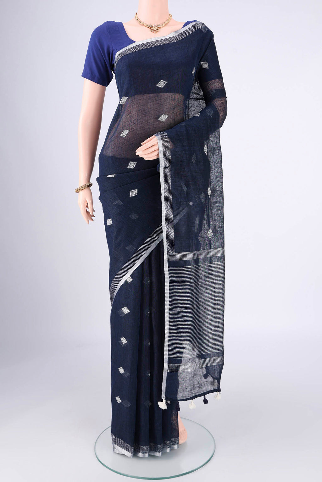 Navy Blue Linen Cotton Saree with Thread Butta on the body and Zari Border.  displayed on a mannequin