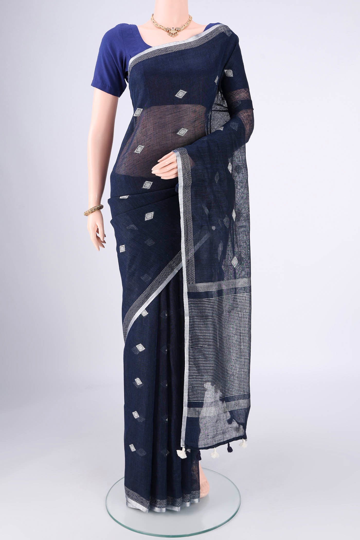 Navy Blue Linen Cotton Saree with Thread Butta on the body and Zari Border.  displayed on a mannequin