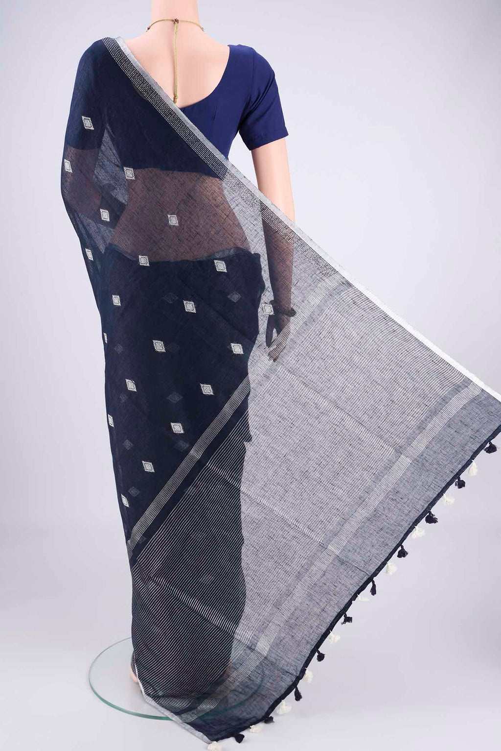 Flat view of Navy Blue Linen Cotton Saree with Thread Butta on the body and Zari Border. 