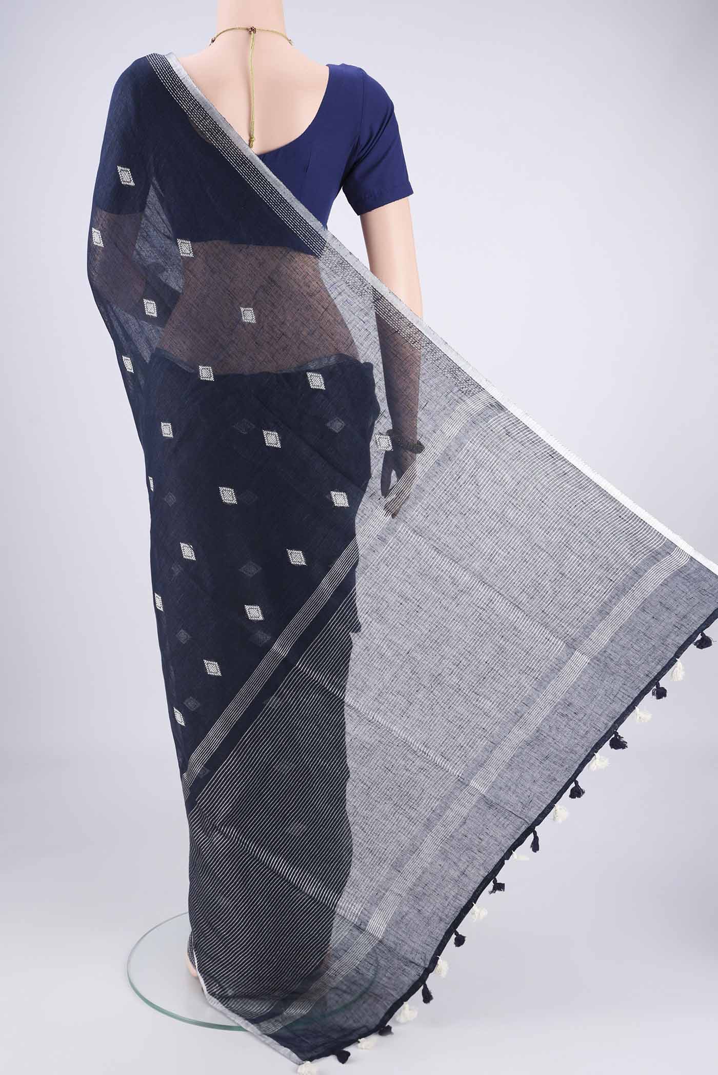 Flat view of Navy Blue Linen Cotton Saree with Thread Butta on the body and Zari Border. 