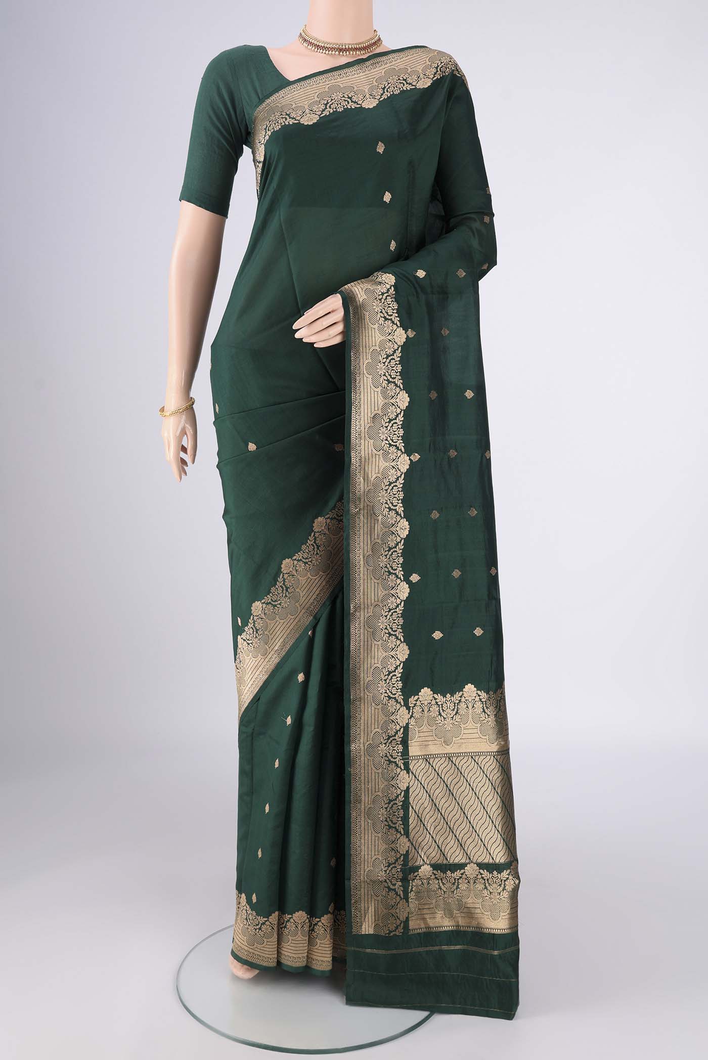 Bottle Green Banarasi Katan Silk Saree with Zari Butta on the body and Zari Border.  displayed on a mannequin