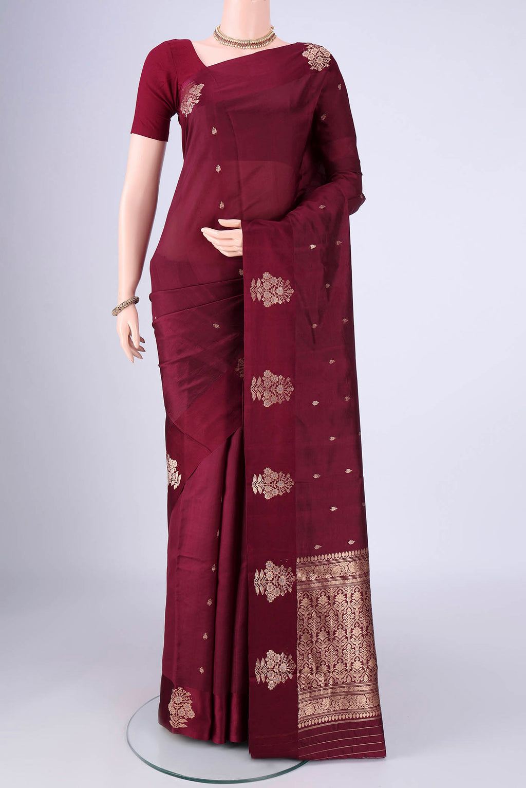 Maroon Banarasi Katan Silk Saree with Zari Butta on the body and Satin Border.  displayed on a mannequin