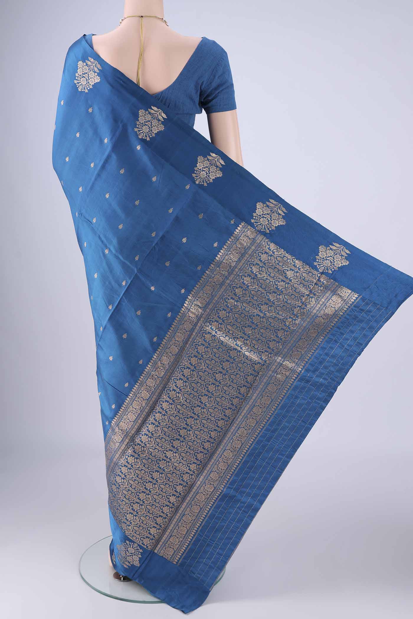 Flat view of Blue Banarasi Katan Silk Saree with Zari Butta on the body and Satin Border. 