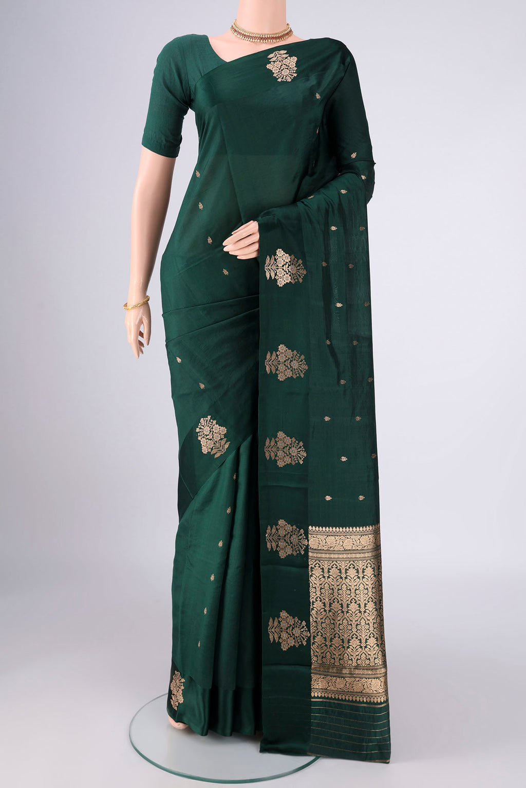 Bottle Green Banarasi Katan Silk Saree with Zari Butta on the body and Plain Border.  displayed on a mannequin