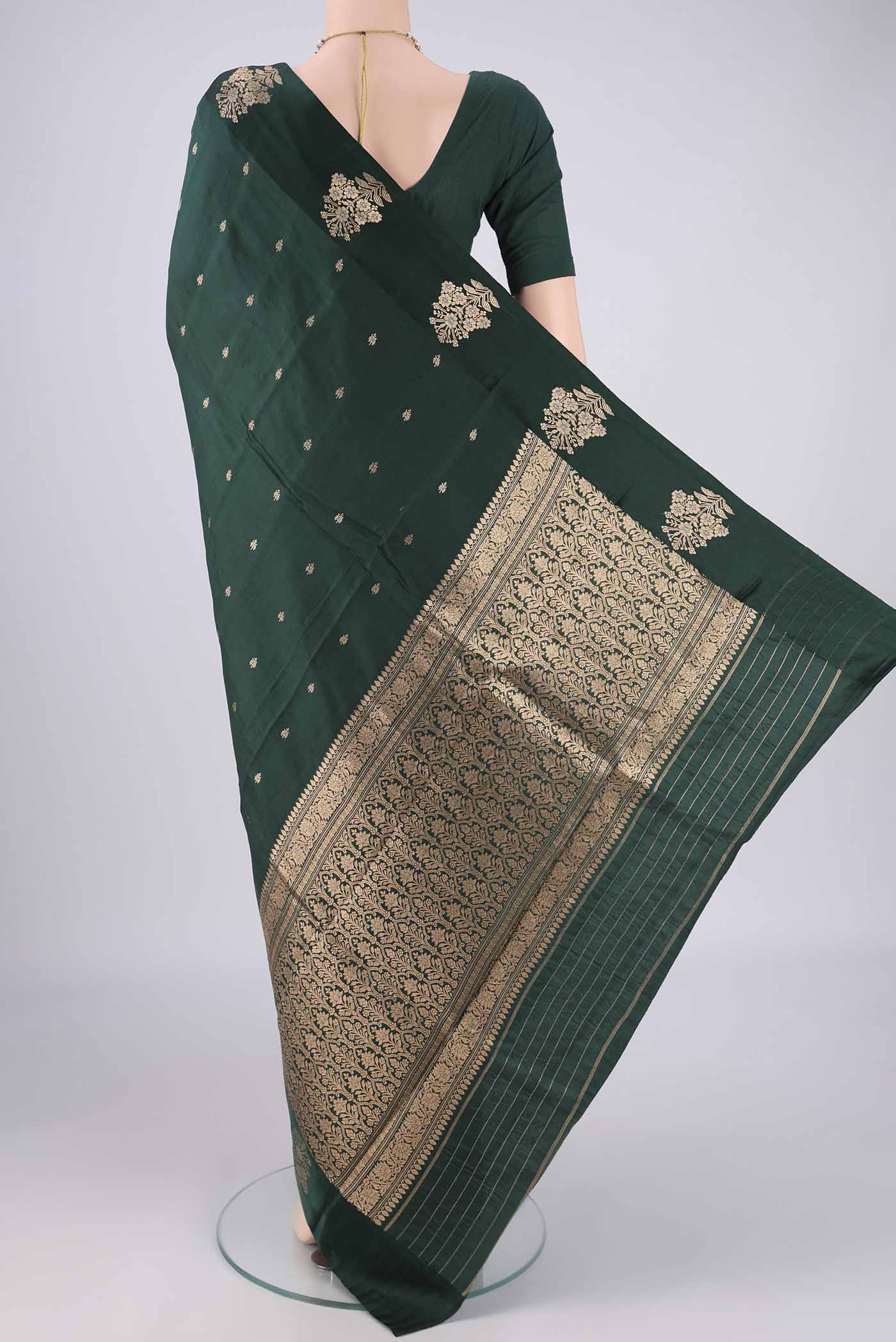 Flat view of Bottle Green Banarasi Katan Silk Saree with Zari Butta on the body and Plain Border. 