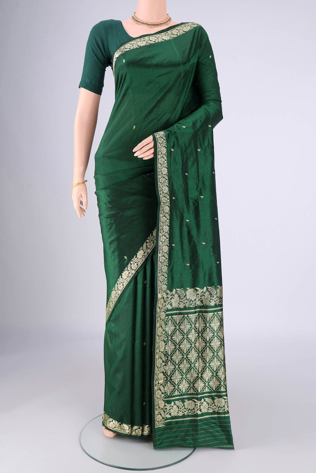 Bottle Green Banarasi Silk Saree with Thread Butta on the body and Thread Border.  displayed on a mannequin