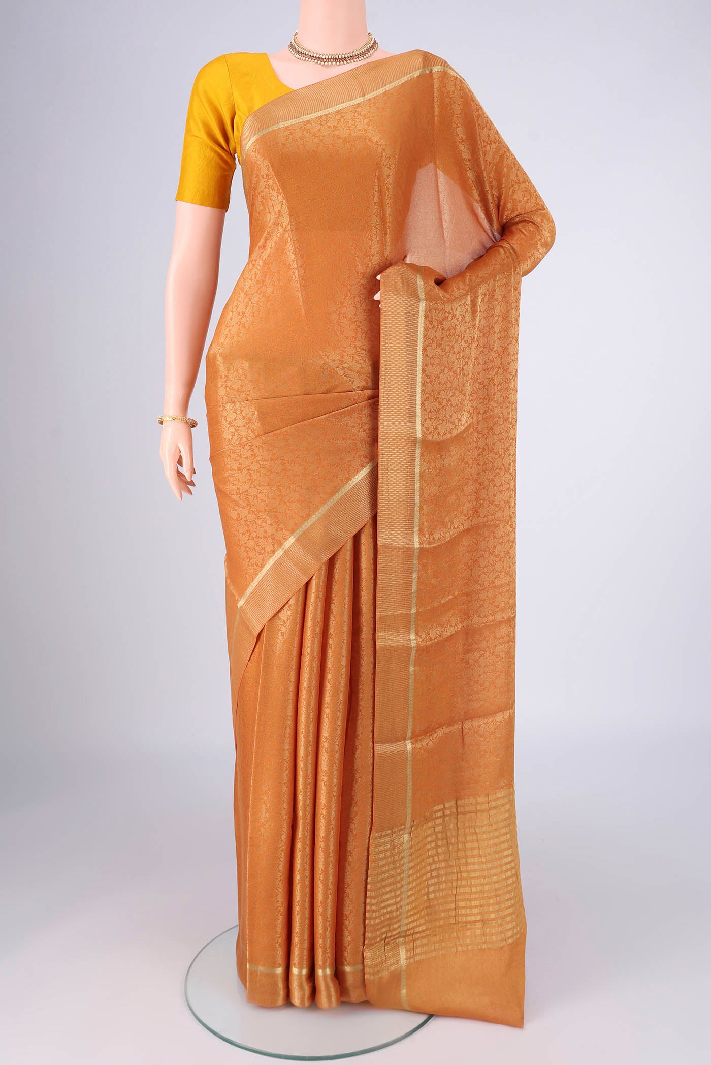 Mustard Mysore Crepe Saree with Zari Brocade on the body and Zari Border.  displayed on a mannequin