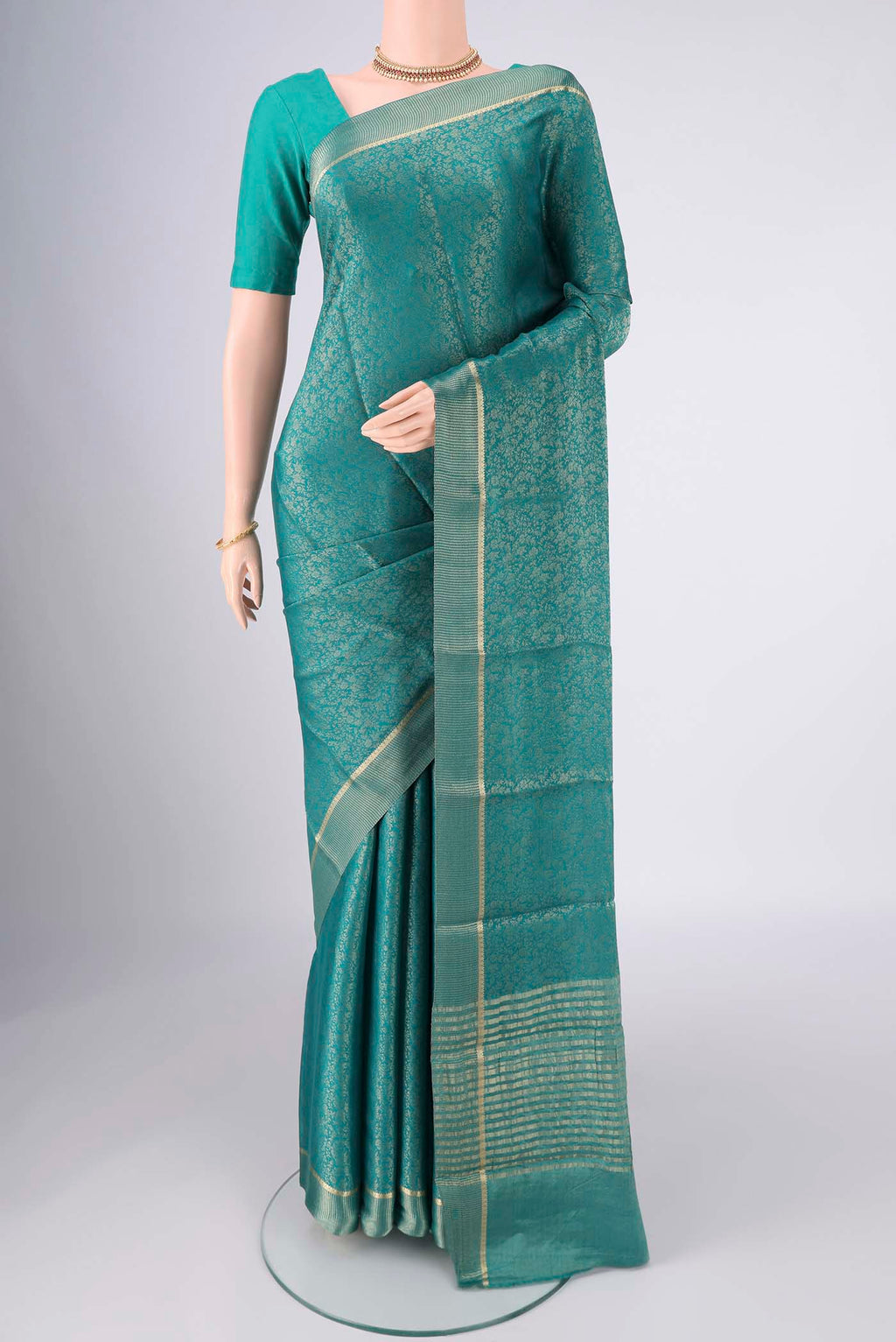 Turquoise Mysore Crepe Saree with Zari Butta on the body and Zari Border.  displayed on a mannequin