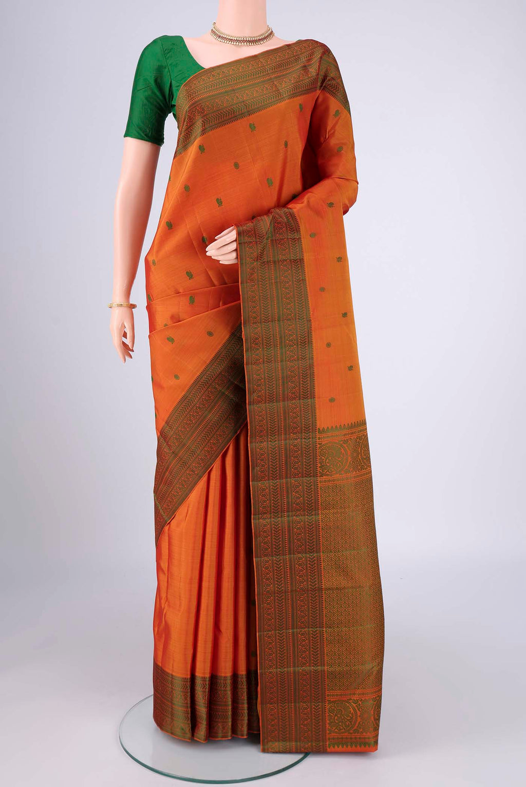 Mustard Kanchipuram Silk Saree with Thread Butta on the body and Thread Border.  displayed on a mannequin