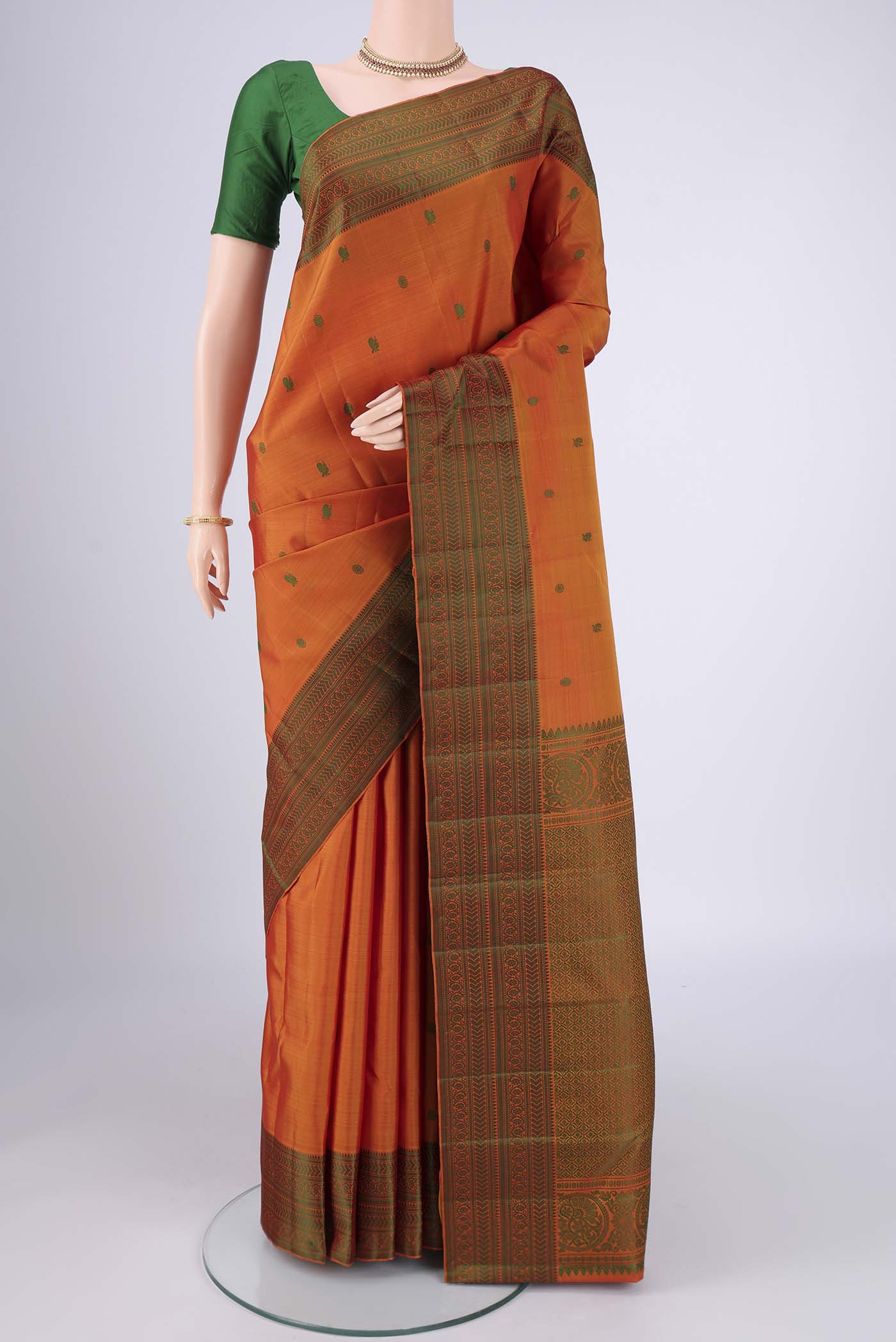 Mustard Kanchipuram Silk Saree with Thread Butta on the body and Thread Border.  displayed on a mannequin