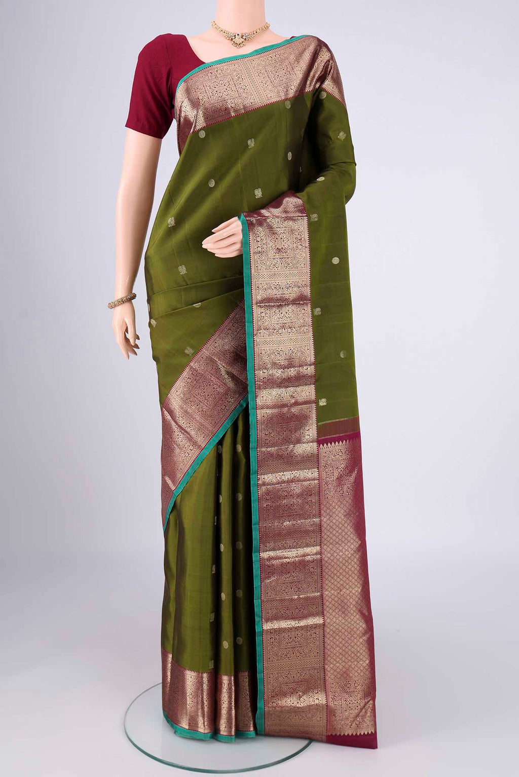 Pure Silk Pure Zari Mehandi Green Kanchipuram Saree with Zari Butta on the body and Zari Border.  displayed on a mannequin