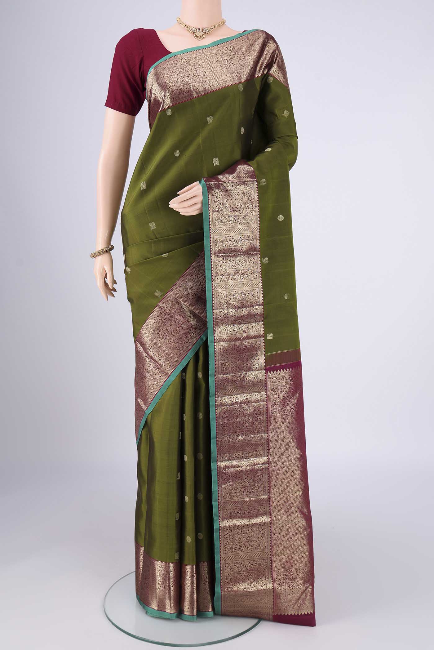 Pure Silk Pure Zari Mehandi Green Kanchipuram Saree with Zari Butta on the body and Zari Border.  displayed on a mannequin
