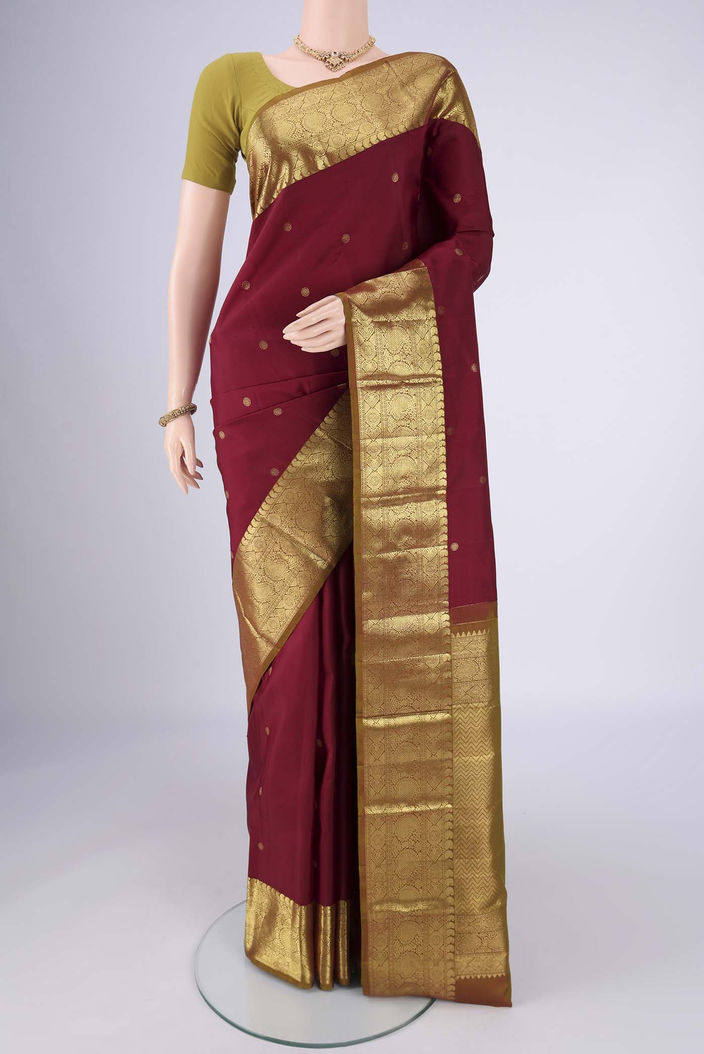 Pure Silk Pure Zari Maroon Kanchipuram Saree with Zari Butta on the body and Zari Border.  displayed on a mannequin
