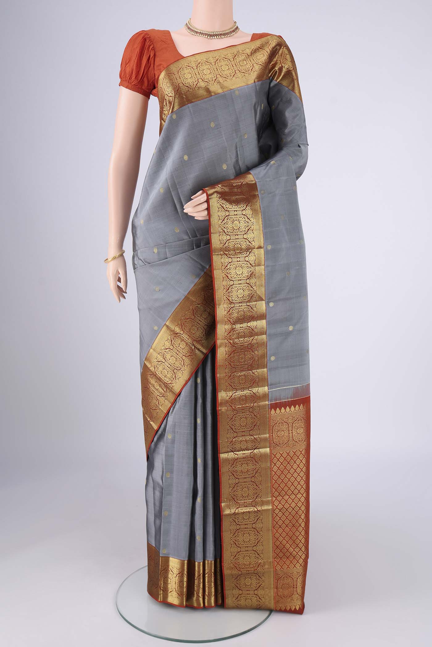Grey Kanchipuram Silk Saree with Zari Butta on the body and Zari Border.  displayed on a mannequin